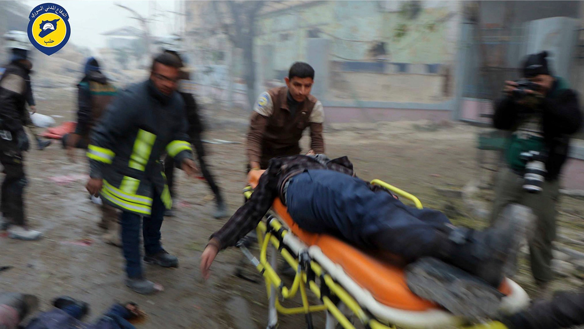 Nov. 30, 2016: This photo provided by the Syrian Civil Defense White Helmets, which has been authenticated based on its contents and other AP reporting, shows Civil Defense workers carrying a victim on a stretcher after artillery fire struck the Jub al-Quba district in Aleppo.