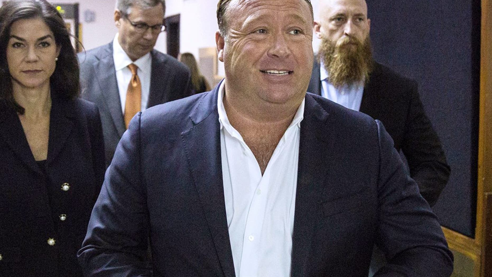 FILE - In this April 17, 2017, file photo, "Infowars" host Alex Jones arrives at the Travis County Courthouse in Austin, Texas. Jones filed a motion Friday, July 20, 2018, to dismiss a defamation lawsuit filed by families of some of the 26 people killed in the 2012 Sandy Hook school shooting in Newtown, Conn. The music streaming service Spotify says it has removed some episodes of ââ¬ÅThe Alex Jones Showââ¬Â podcast for violating its hate content policy. The company said late Wednesday that it takes reports of hate content seriously and reviews any podcast or song reported by customers. (Tamir Kalifa/Austin American-Statesman via AP, File)