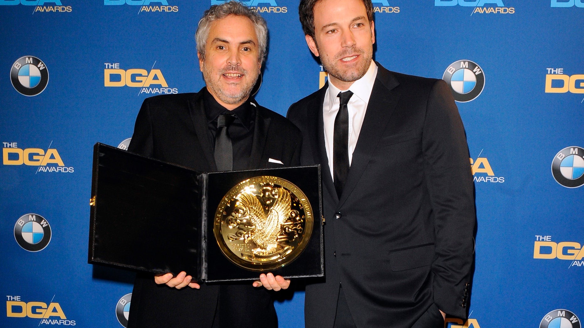 January 25, 2014. Actor and director Ben Affleck (R) presents Mexican director Alfonso Cuaron with the Feature Film award for "Gravity"during the 66th annual Directors Guild of America Awards in Beverly Hills, California.