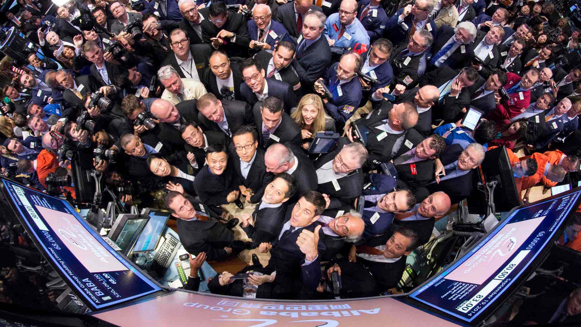 Alibaba Group Holding Ltd founder Jack Ma joined by Alibaba executives and NYSE CEO Tom Farley gather around the post during their IPO at the New York Stock Exchange in New York September 19, 2014. A new survey shows that investors are more confident in U.S. capital markets than they have been since 2009.