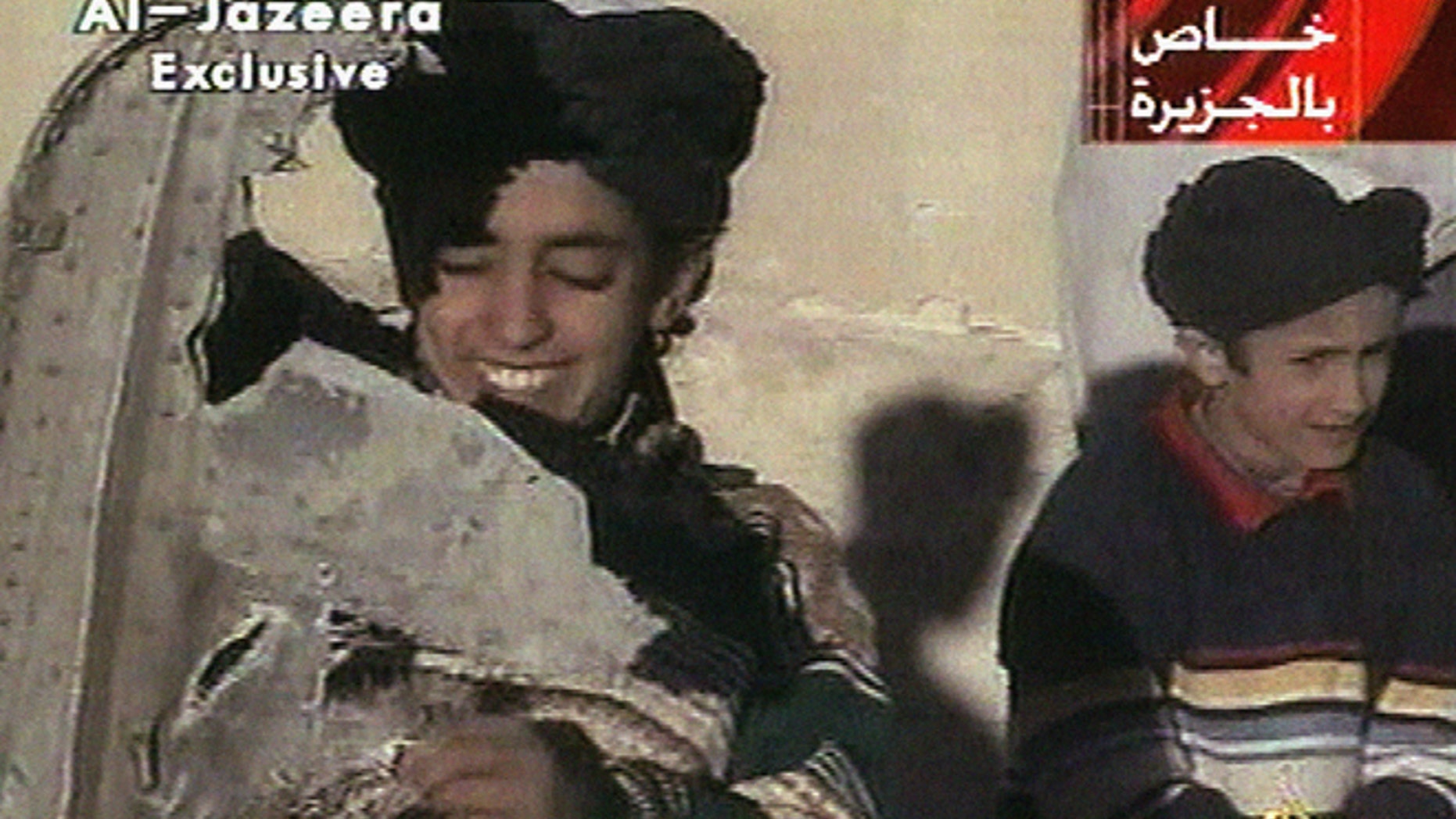 In this image made from video broadcast by the Qatari-based satellite television station Al-Jazeera Wednesday, Nov. 7, 2001, a young boy, left, identified as Hamza bin Laden holds what the Taliban says is a piece of U.S. helicopter wreckage in Ghazni, Afghanistan on Monday, Nov. 5, 2001.