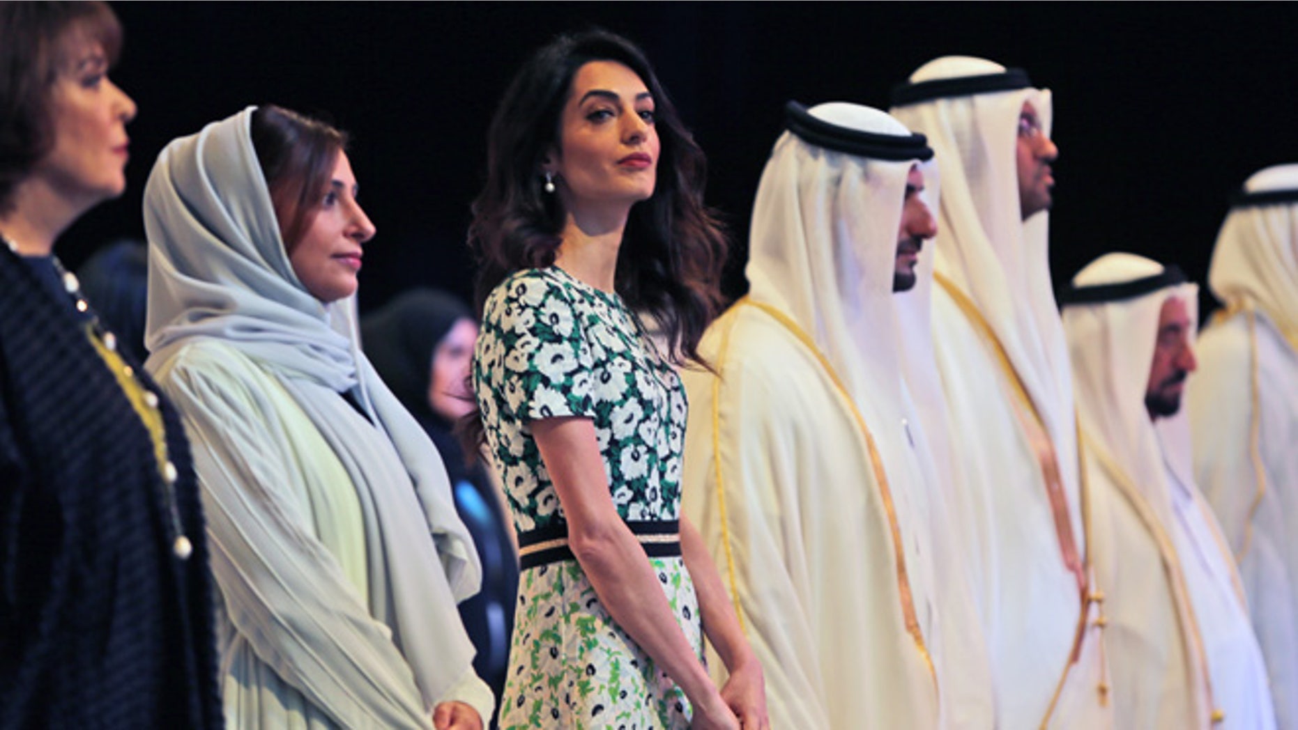 March 20, 2016. Amal Alamuddin Clooney, writer, human rights activist, 3rd left, listens to the national anthem during the opening ceremony of the International Government Communications Forum in Sharjah, United Arab Emirates.