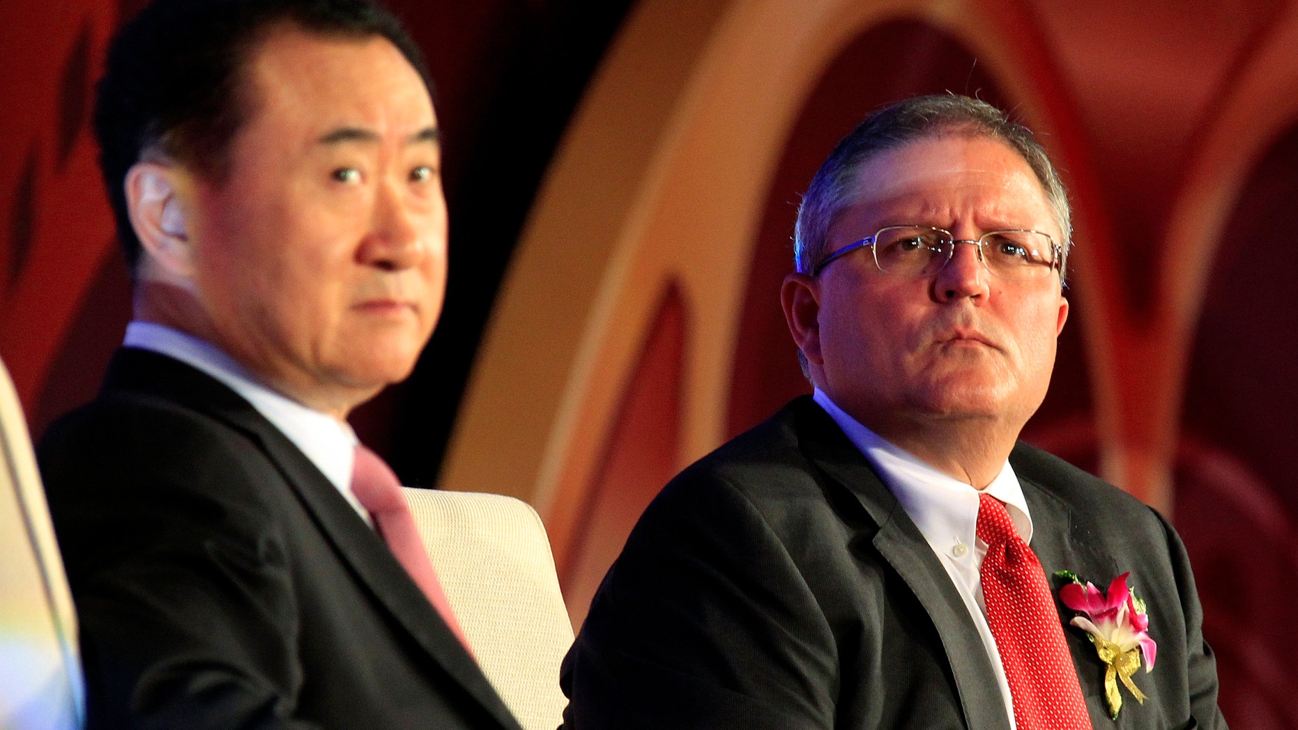 Gerry Lopez (R), chief executive of AMC Entertainment, listens to a question next to Wang Jianlin, president of Wanda Group, during a media conference after an official signing ceremony in Beijing May 21, 2012.