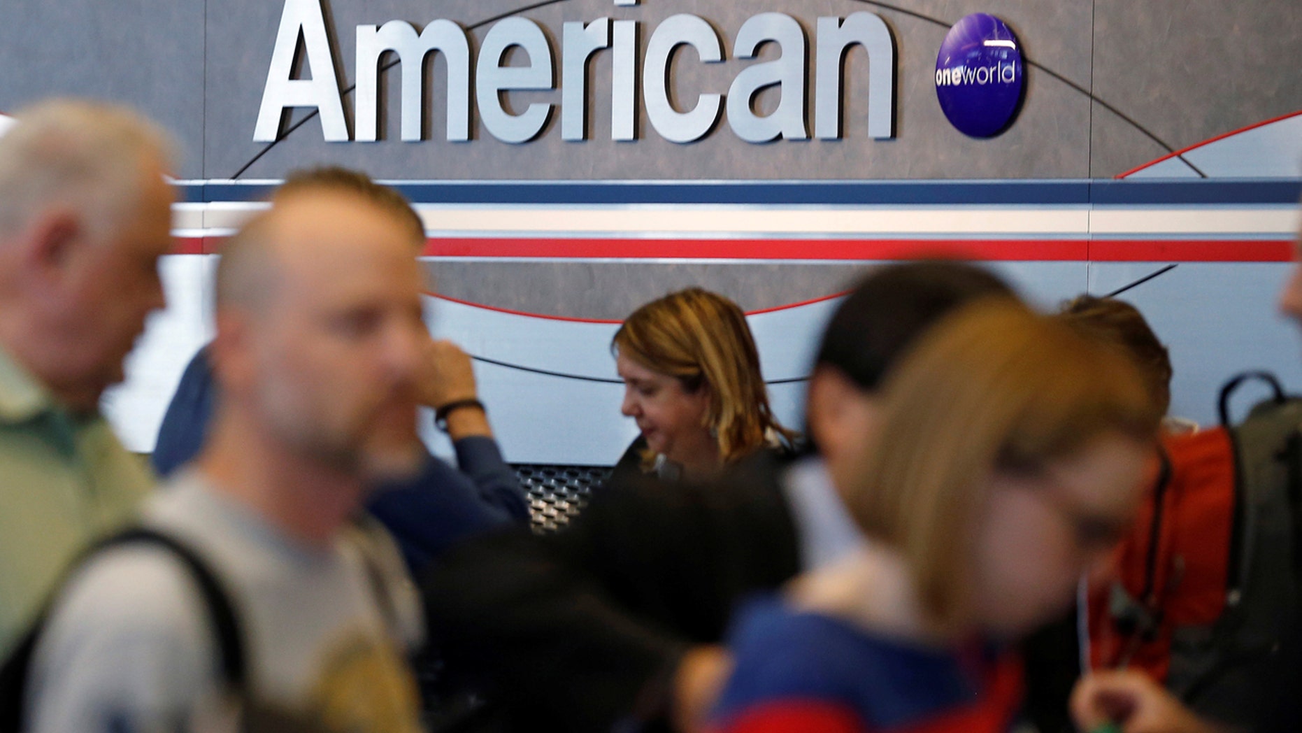 Travelers line up at an American Airlines ticket counter at O'Hare Airport in Chicago, Illinois, May 13, 2014.