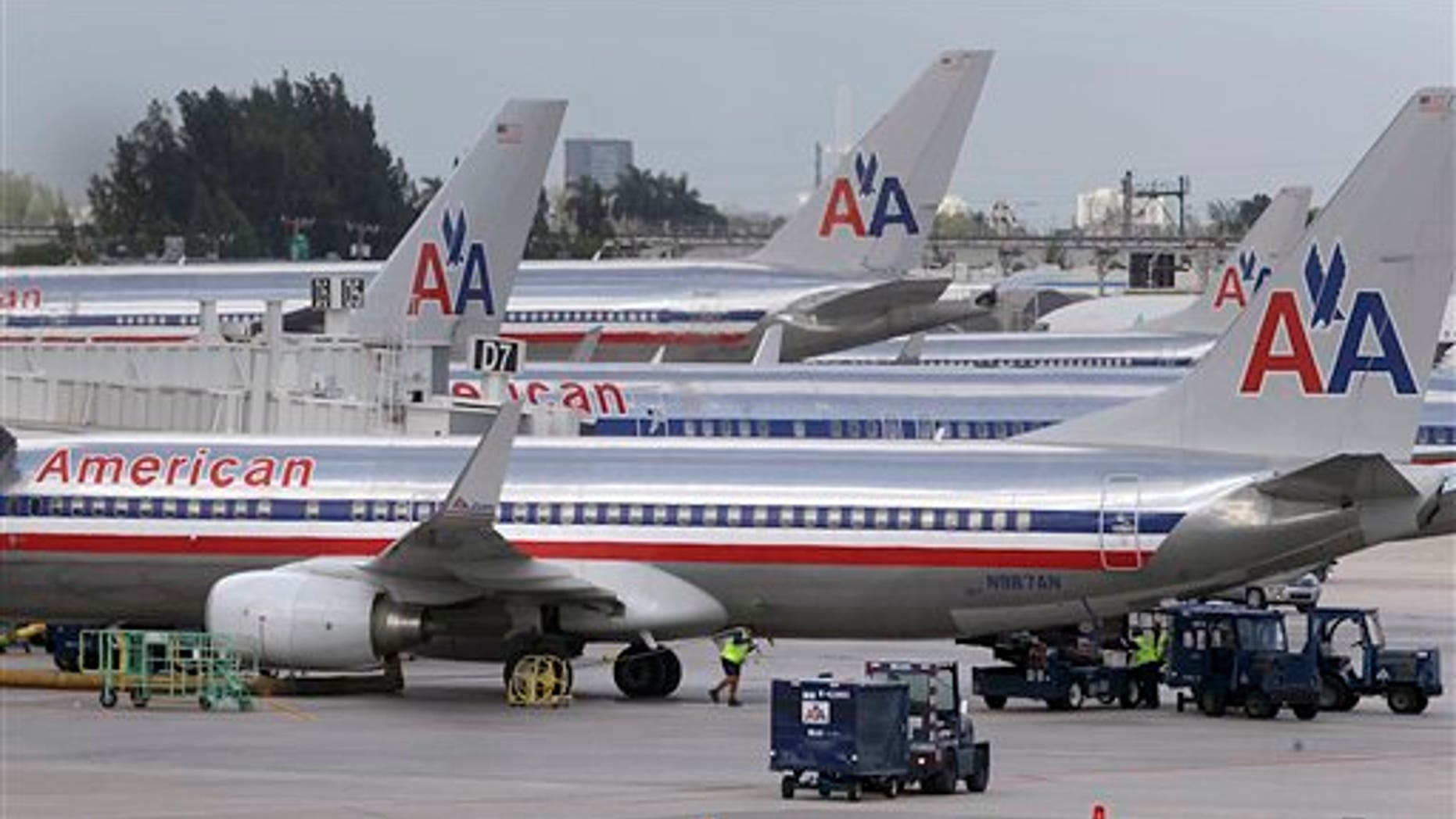 American Airlines jets are parked at the various gates of Miami International Airport on Tuesday, Sept. 18, 2012 in Miami. American Airlines is sending layoff warning notices to more than 11,000 employees although a spokesman says the company expects job losses to be closer to 4,400. The notices went out to mechanics and ground workers whose jobs will be affected as American goes through a bankruptcy restructuring. (AP Photo/The Miami Herald, Carl Juste) MAGS OUT