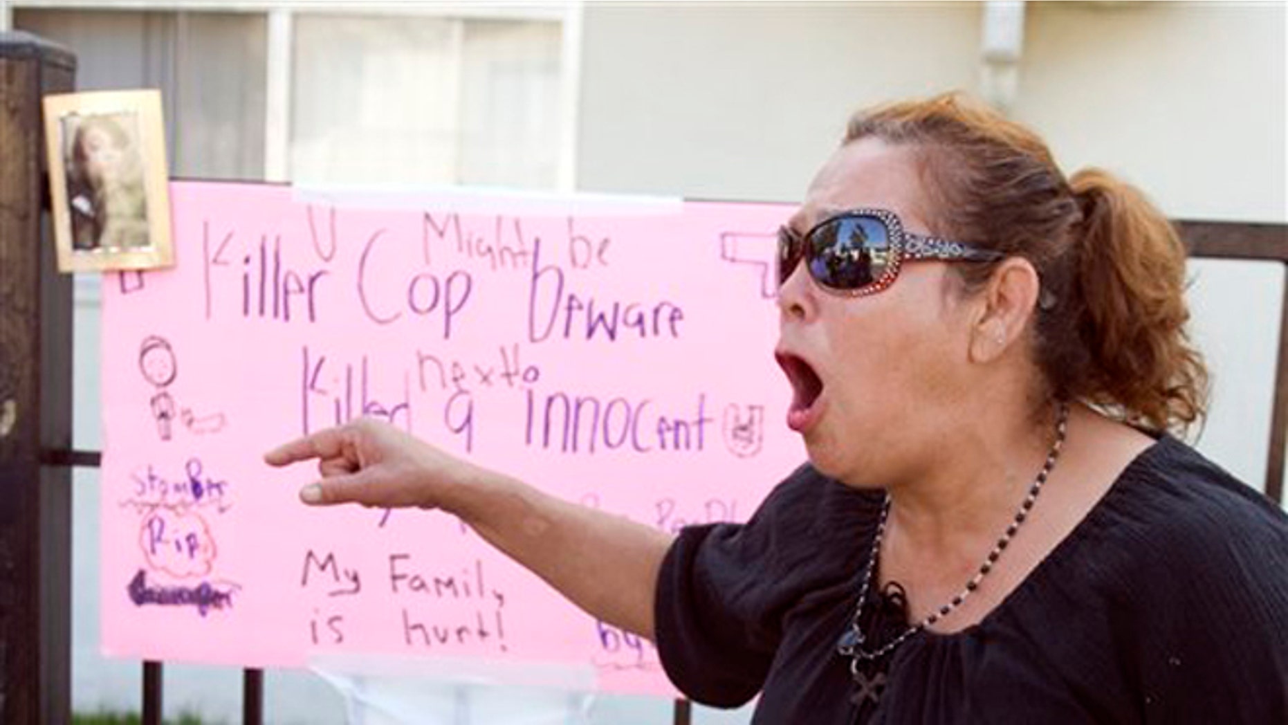 July 23, 2012: Maria, who wouldn't give her last name because she said she fears the police, shouts "no mas", at a memorial on Anna Drive in Anaheim, Calif. for Manuel Angel Diaz, 25, of Santa Ana.