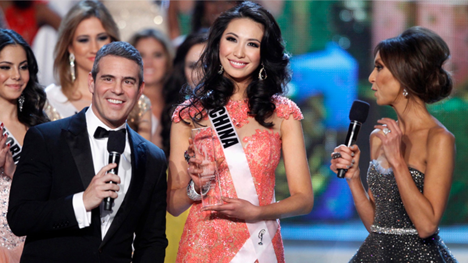 Miss China Xu Jidan poses with hosts Andy Cohen (L) and Giuliana Rancic after receiving the Best National Costume award during the Miss Universe pageant at Planet Hollywood Resort and Casino in Las Vegas, Nevada December 19, 2012. REUTERS/Steve Marcus (UNITED STATES - Tags: ENTERTAINMENT) FOR EDITORIAL USE ONLY. NOT FOR SALE FOR MARKETING OR ADVERTISING CAMPAIGNS - RTR3BRN2