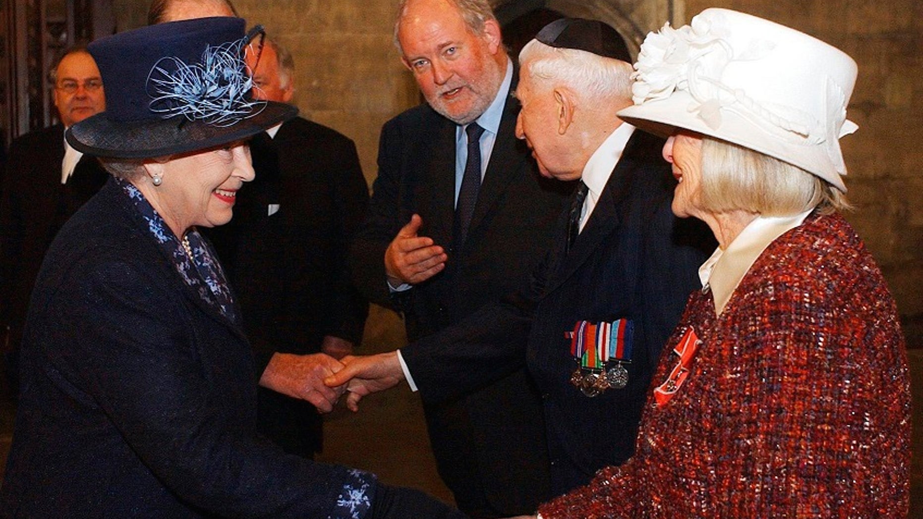 FILE - In this Thursday, Jan. 27, 2005 file photo, Britain's Queen Elizabeth II, left, meets Holocaust survivor Gena Turgel during a service to remember victims of the Holocaust in Westminster Central Hall in London on the 60th anniversary of the liberation of Auschwitz. Turgel, a Holocaust survivor who comforted diarist Anne Frank at the Bergen-Belsen concentration camp months before its liberation, has died. She was 95. Britain's chief rabbi, Ephraim Mirvis, said Turgel died Thursday, June 7, 2018. (Kirsty Wigglesworth, Pool Photo via AP, File)