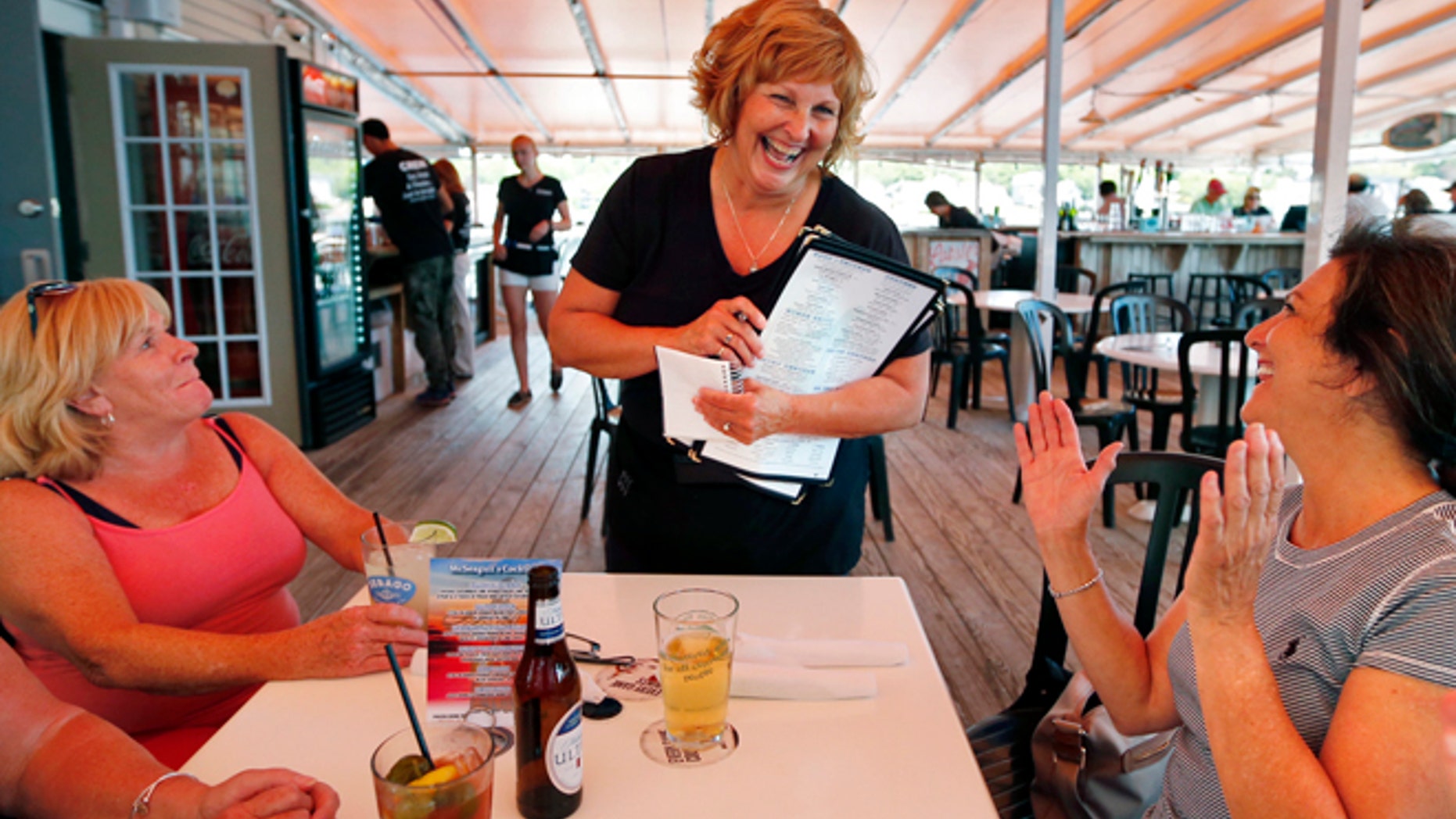 June 23, 2016: Ann LePage chats with diners after taking their order at McSeagull's restaurant in Boothbay Harbor, Maine. (AP)