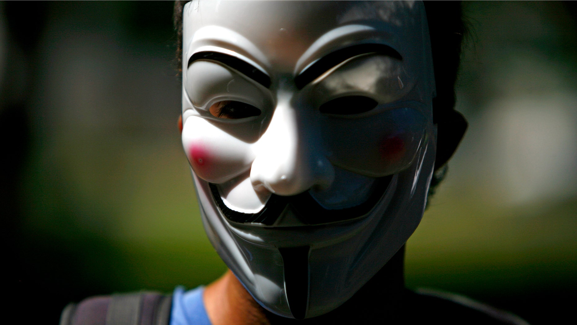 A masked demonstrator protests for Occupy Puerto Rico in San Juan, Puerto Rico, Sunday, Oct. 15, 2011. About 200 people in Puerto Rico have gathered in a financial district dubbed "The Golden Mile" to protest capitalism and government cuts as part of worldwide demonstrations. (AP Photo/Ricardo Arduengo)