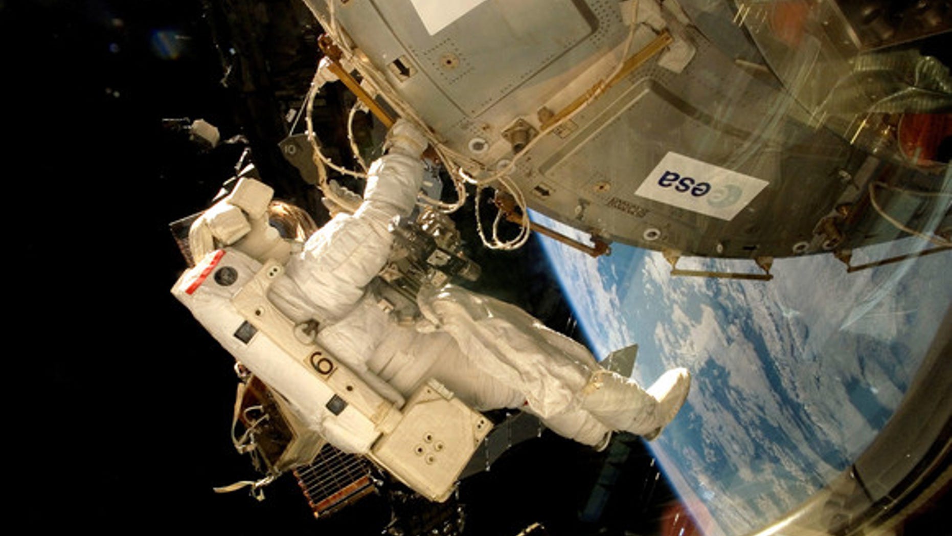 An astronaut fixes the EXPOSE-E platform onto the International Space Station. (ESA)