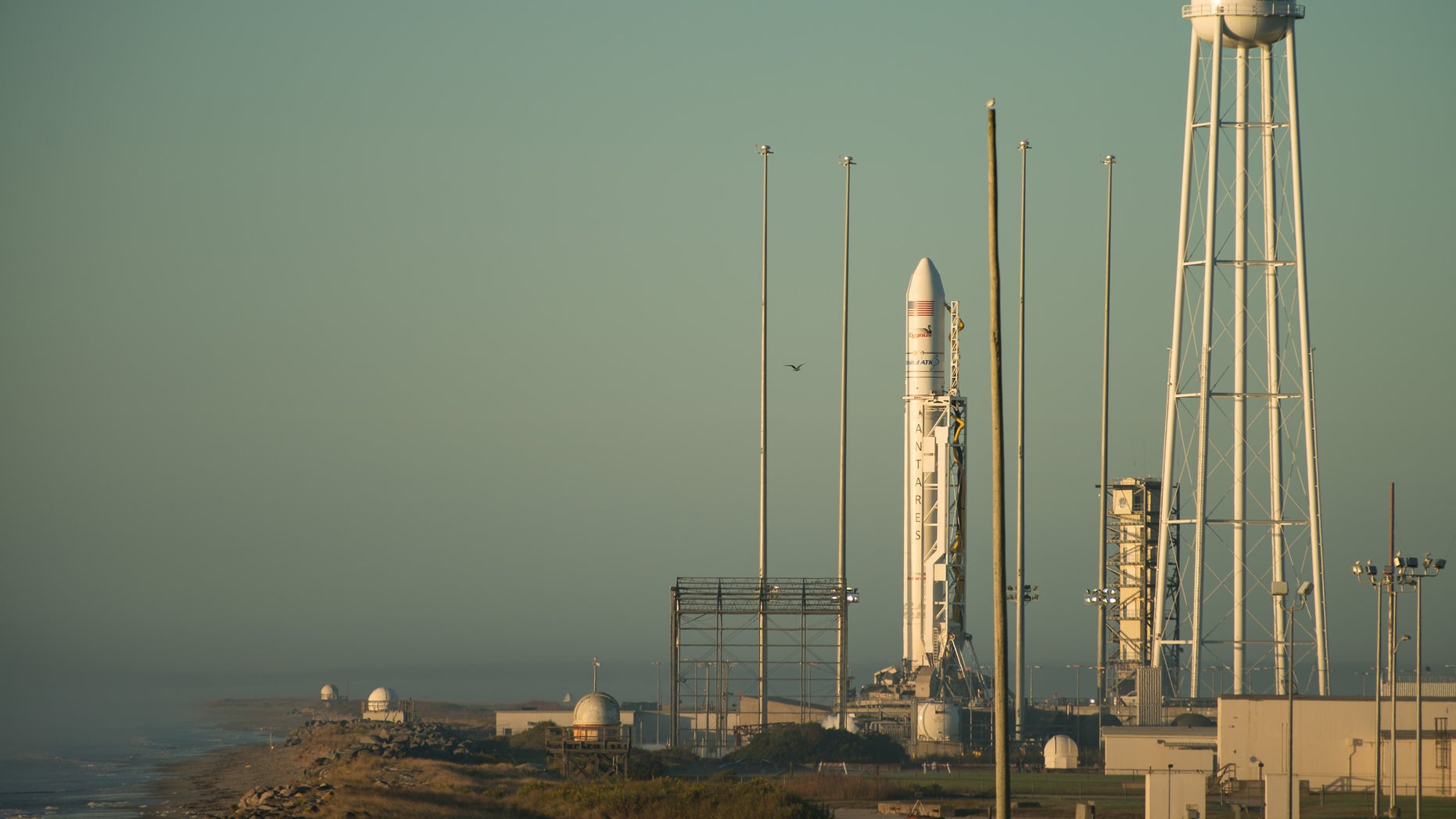 The Orbital ATK Antares rocket, with the Cygnus spacecraft onboard, stands tall on the launchpad as the sun rises behind it on Sunday (Oct. 16) at NASA's Wallops Flight Facility in Virginia.