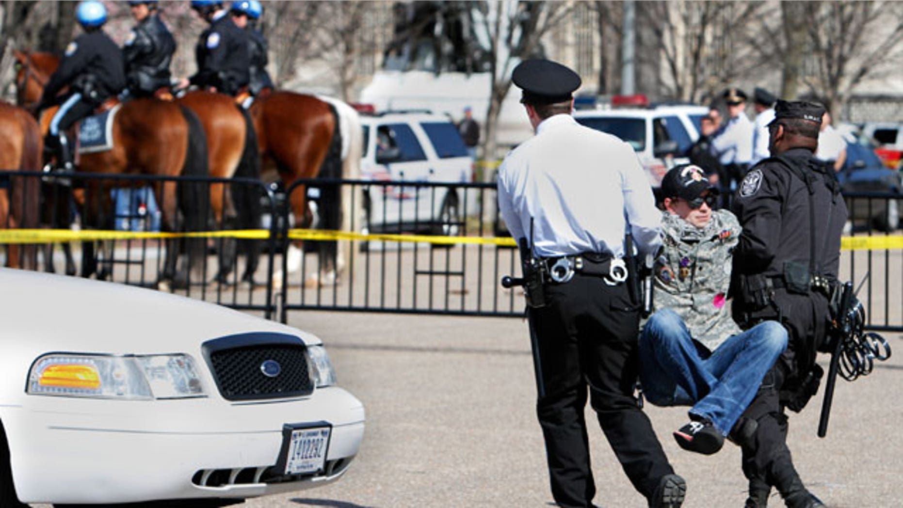A unidentified protester lifts his legs as he is arrested by U.S. Park Police near the White House while protesting against war on the 8th anniversary of the Iraq invasion in Washington, on Saturday, March 19, 2011. (AP)