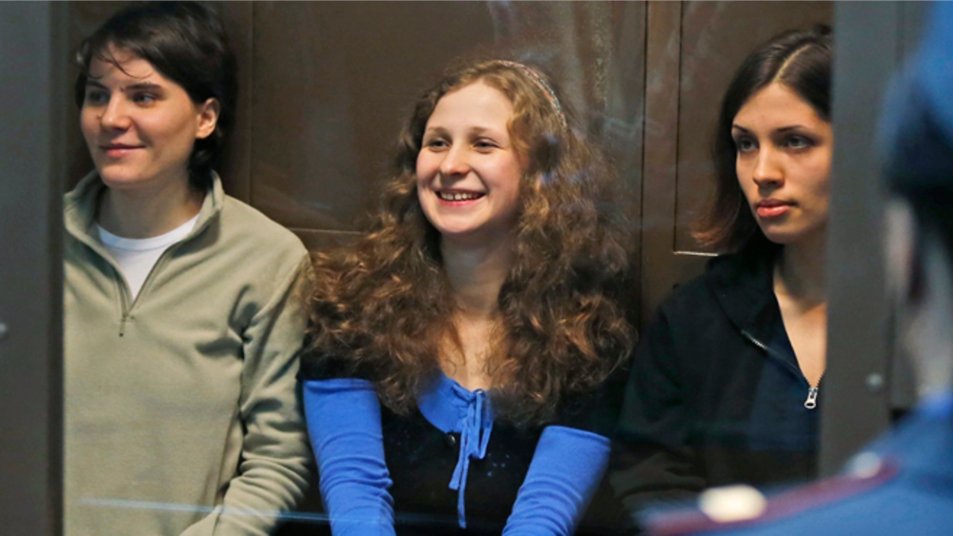 Oct. 10, 2012: In this file photo, feminist punk group Pussy Riot members, from left, Yekaterina Samutsevich, Maria Alekhina and Nadezhda Tolokonnikova sit in a glass cage at a court room in Moscow, Russia.