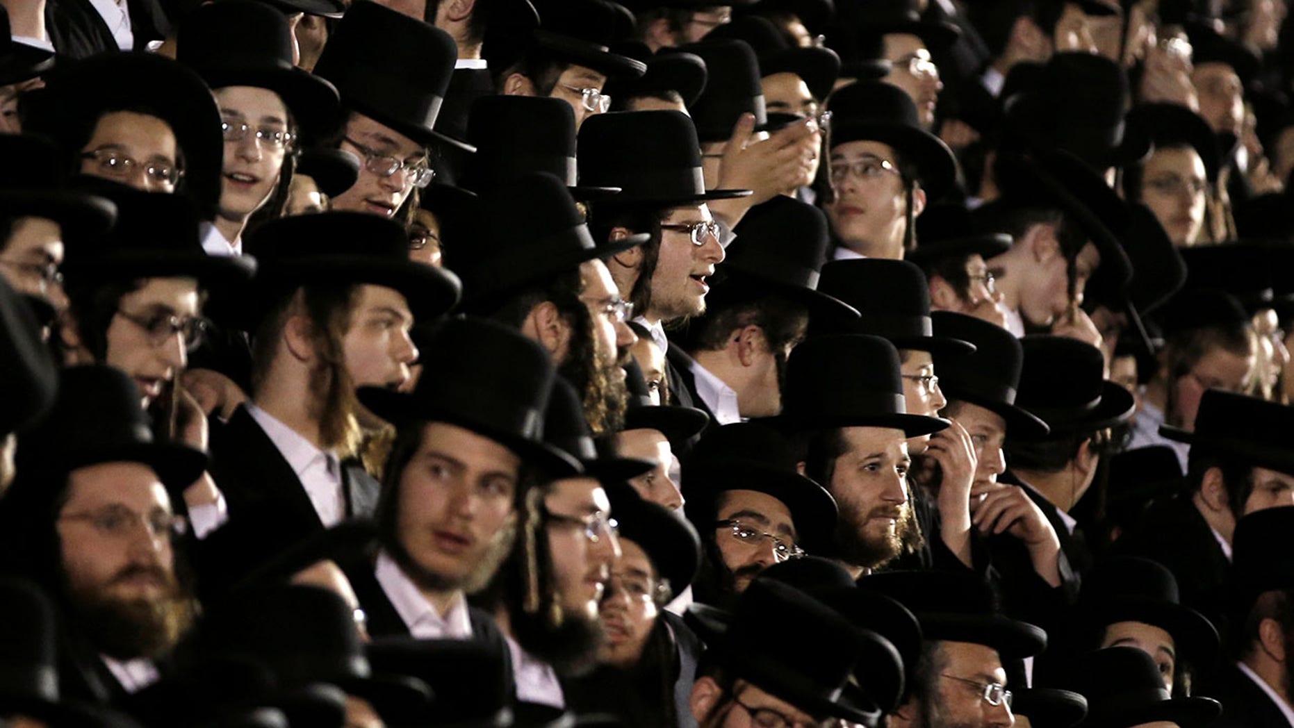 Orthodox Jews of the Satmar Hasidim crowd bleachers near a bonfire in the New York village of Kiryas Joel.
