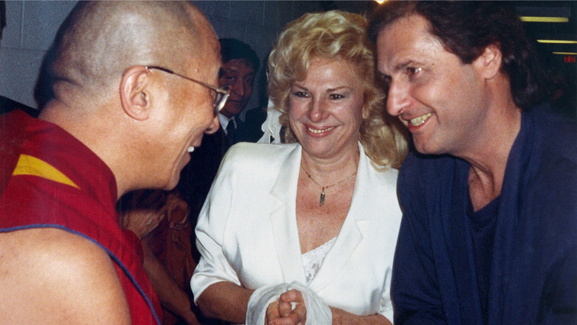 In this October 1989 file photo, the Dalai Lama, left, talks to the comedy writing and acting team of Renee Taylor and Joe Bologna, during a backstage visit prior to the Dalai Lama's convocation on the subject of compassion at UC Irvine in Irvine, Calif.