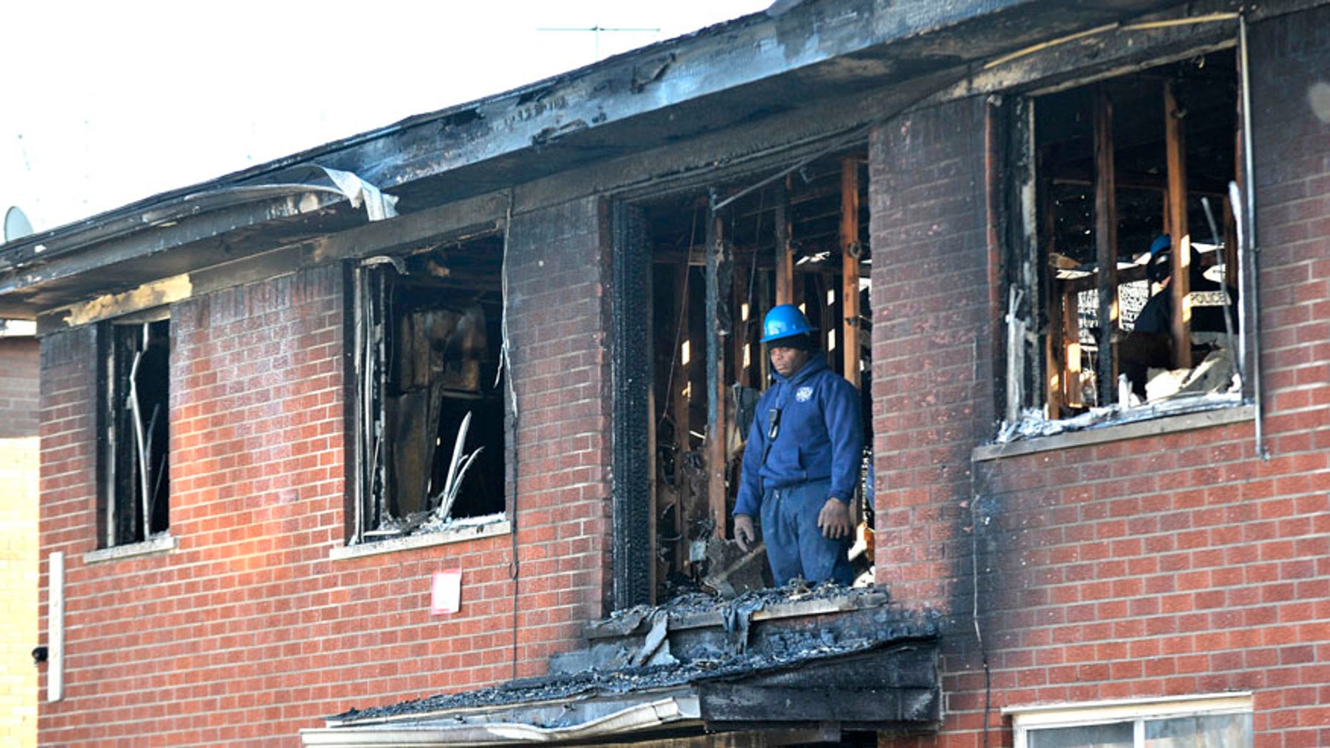A Detroit Fire Department investigator stands on the second floor after a deadly fire at an apartment complex Wednesday, March 8, 2016, in Detroit. (Todd McInturf/Detroit News via AP)