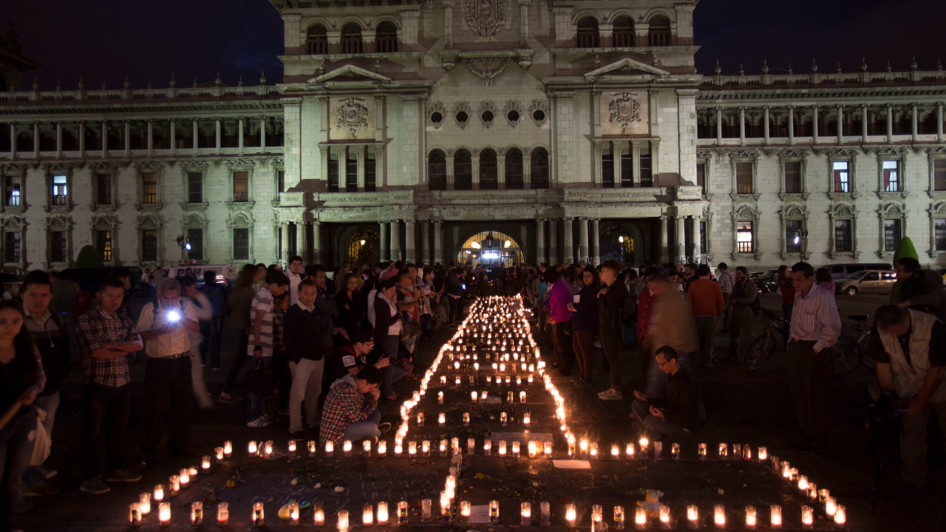 People hold a candlelight vigil outside the National Palace in remembrance of the girls who died in a fire at the Virgin of the Assumption Safe Home in Guatemala City, Thursday, March 9, 2017.