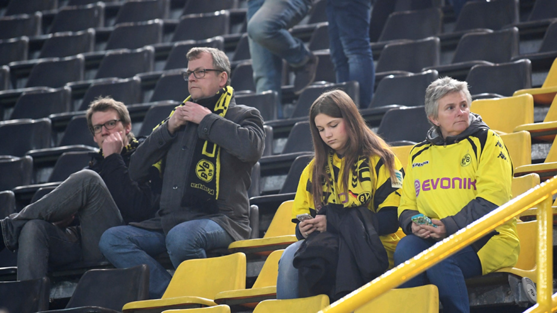 Borussia Dortmund fans sit in the Signal Iduna Park in Dortmund, Germany, Tuesday, April 11, 2017. The first leg of the Champions League quarter final soccer match between Borussia Dortmund and AS Monaco had been cancelled. (AP Photo/Federico Gambarini/dpa via AP)