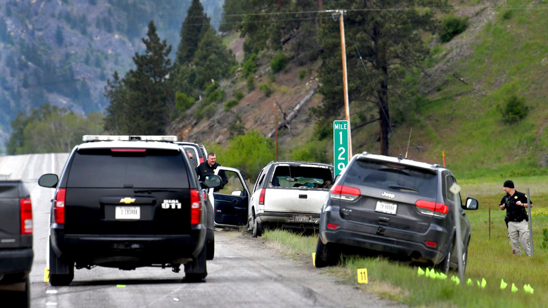 Law enforcement personnel investigate the scene of a shootout on Interstate 90 east of Missoula following a high-speed chase Tuesday, May 16, 2017. The white SUV was the vehicle being pursued. The driver of the SUV has been arrested and a passenger was shot by law enforcement and taken to the hospital. (Kurt Wilson/The Missoulian via AP)