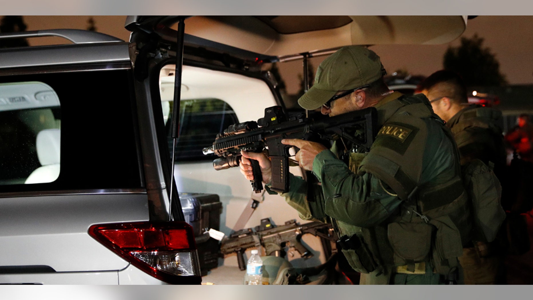 An ATF agent checks his weapon as he gets ready for a raid Wednesday morning, May 17, 2017, in Los Angeles. Hundreds of federal and local law enforcement fanned out across Los Angeles, serving arrest and search warrants as part of a three-year investigation into the violent and brutal street gang MS-13. (AP Photo/Jae C. Hong)
