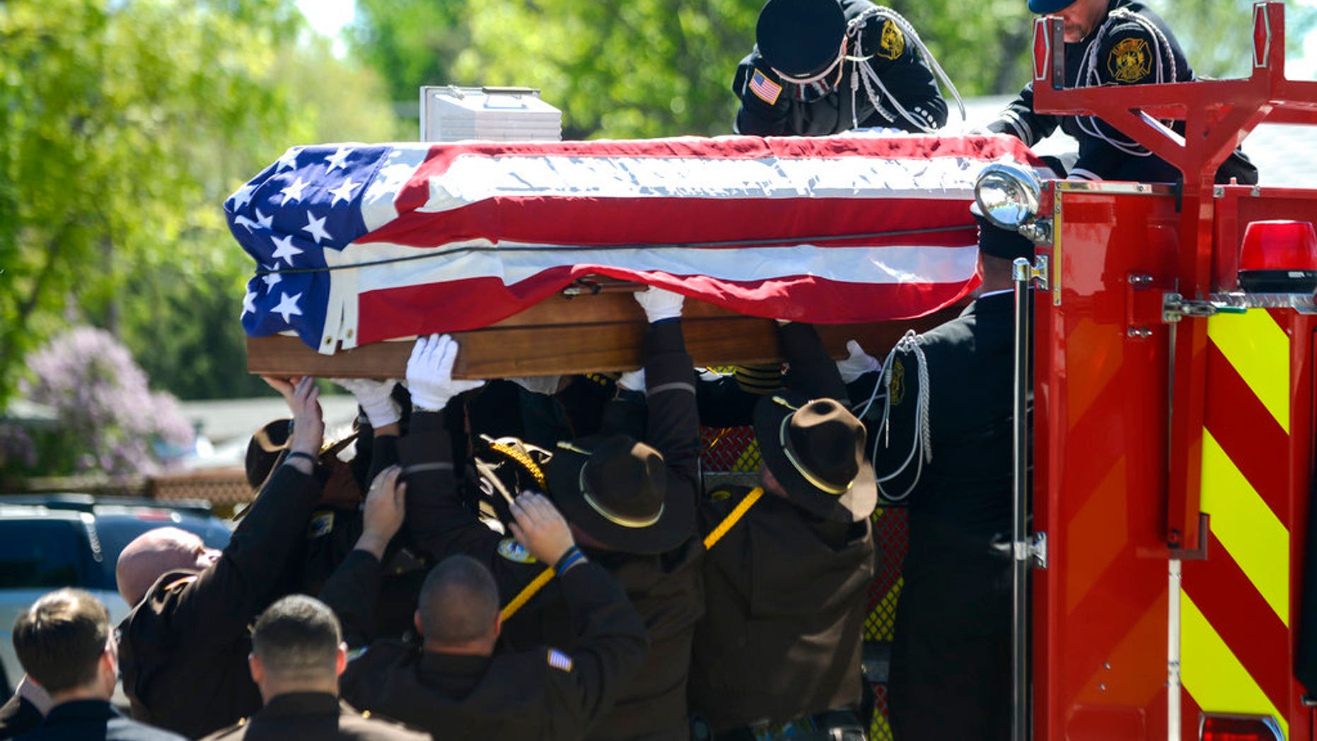 Law enforcement lift Deputy Mason Moore's casket down from a firetruck in front of Three Forks High School, the end of the funeral procession in Three Forks, Montana, on Tuesday.