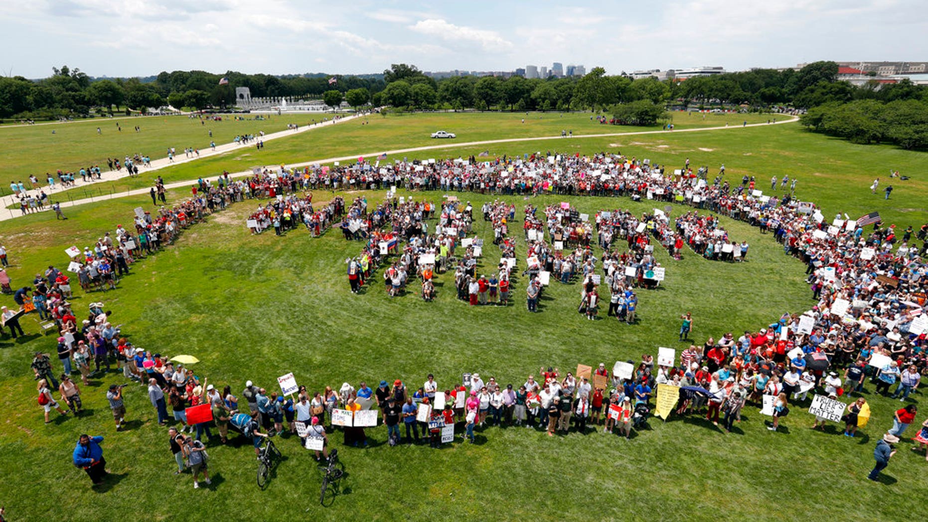 Protesters form letters that spell "Impeach Trump" at a rally to protest President Trump and his policies on the National Mall June 3.