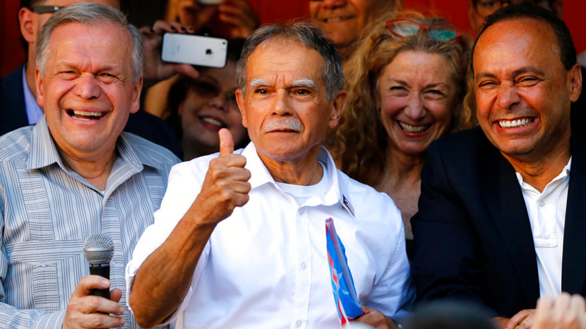 FILE- In this May 18, 2017 file photo, Puerto Rican nationalist Oscar Lopez Rivera, center, reacts to the crowd as his brother Jose, left, and U.S. Rep Luis Gutierrez, D-Ill., join him at a gathering in his honor in Chicago's Humboldt Park neighborhood. New York City's annual Puerto Rican Day parade will take place under a cloud of controversy this year because of a decision by organizers to honor Lopez Rivera, who spent decades in prison because of his involvement with the terrorist group FALN. (AP Photo/Charles Rex Arbogast, File)
