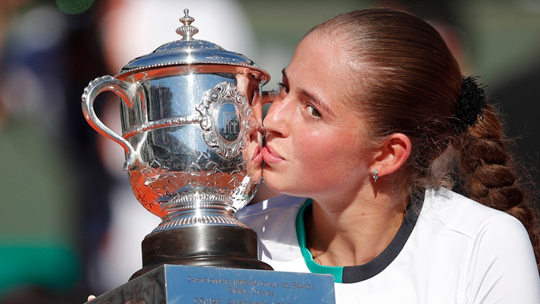 Latvia's Jelena Ostapenko kisses the trophy after winning the women's final match of the French Open tennis tournament against Romania's Simona Halep in three sets 4-6, 6-4, 6-3, at the Roland Garros stadium, in Paris, France, Saturday, June 10, 2017. (AP Photo/Christophe Ena)