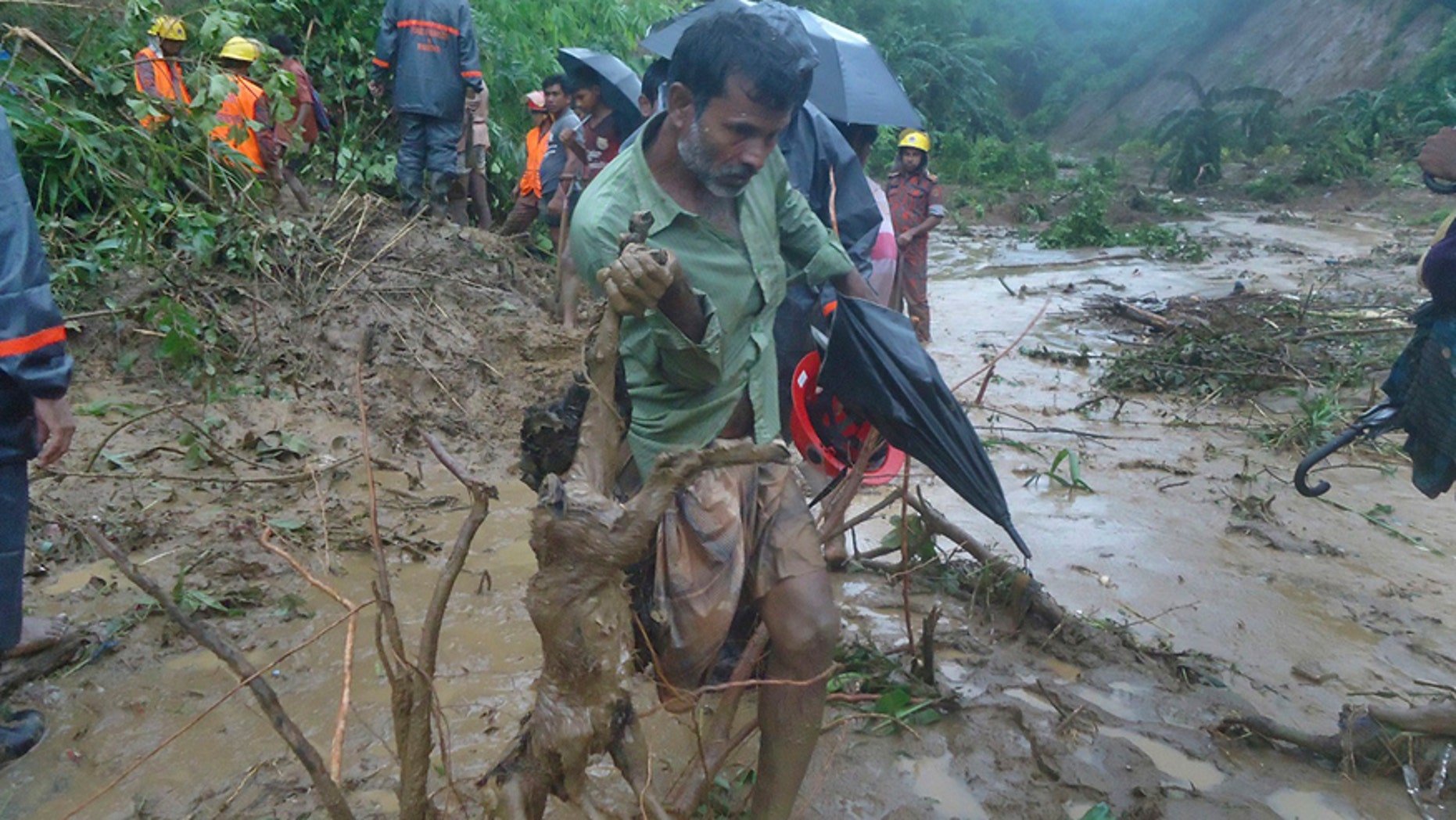 A man carries the carcass of a goat as rescuers search amid the mud after a landslide in Bandarban, Bangladesh, Tuesday, June 13, 2017. Heavy rains triggered landslides that killed dozens in southeast Bangladesh, officials said Tuesday, as police and soldiers struggled to reach the remote districts with aid. (AP Photo)