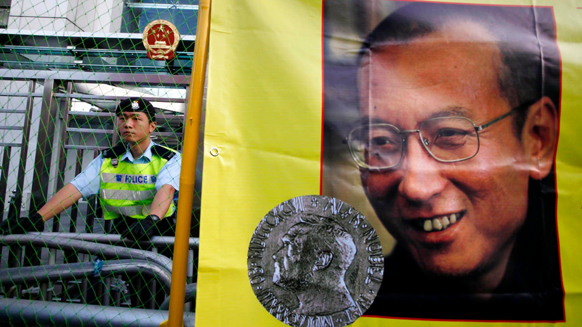 A police officer stands guard beside a picture of jailed Chinese dissident Liu Xiaobo, in December 2010.
