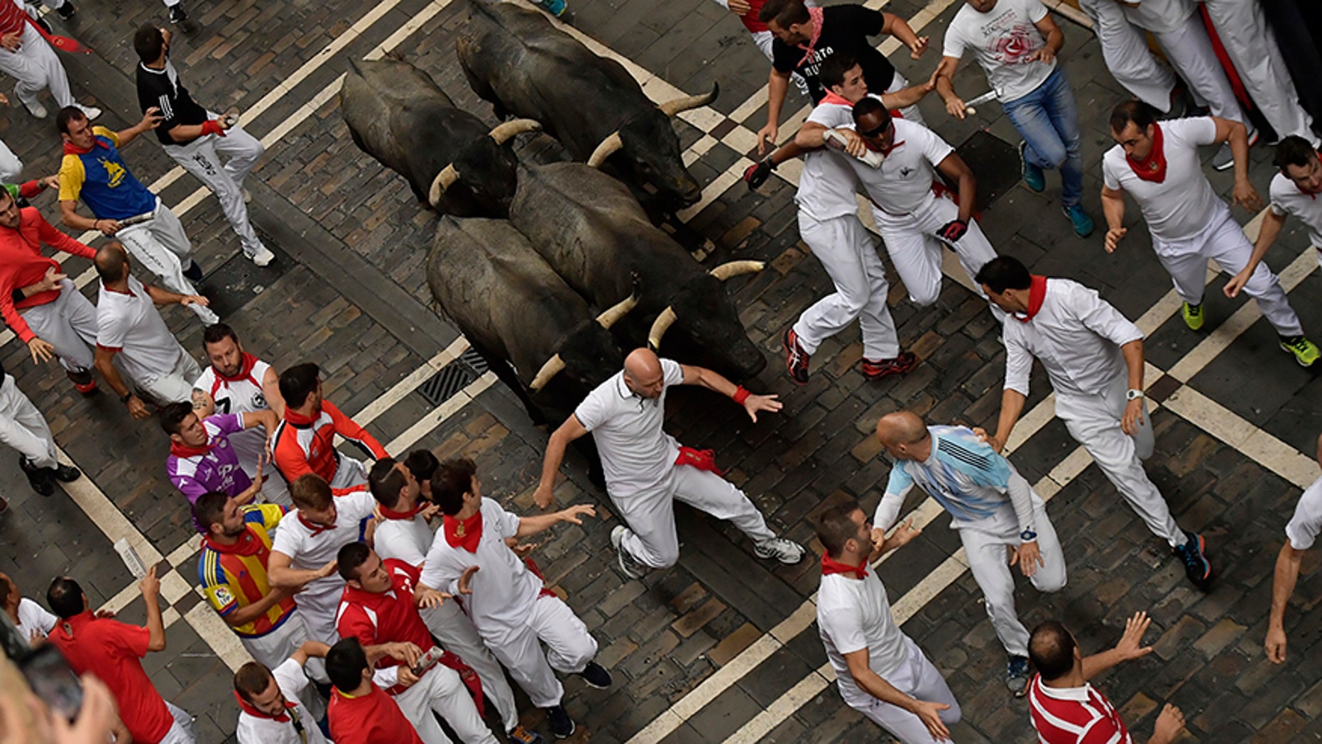 Revellers run in front of Jose Escolar fighting bulls during the second running of the bulls at the San Fermin Festival, in Pamplona, northern Spain, Saturday, July 8, 2017. Revellers from around the world flock to Pamplona every year to take part in the eight days of the running of the bulls. (AP Photo/Alvaro Barrientos)