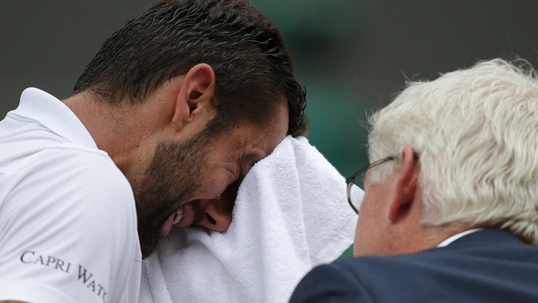 Croatia's Marin Cilic has treatment on his foot as he takes a medical timeout during the Men's Singles final match against Switzerland's Roger Federer on day thirteen at the Wimbledon Tennis Championships in London Sunday, July 16, 2017. (Daniel Leal-Olivas/Pool Photo via AP)