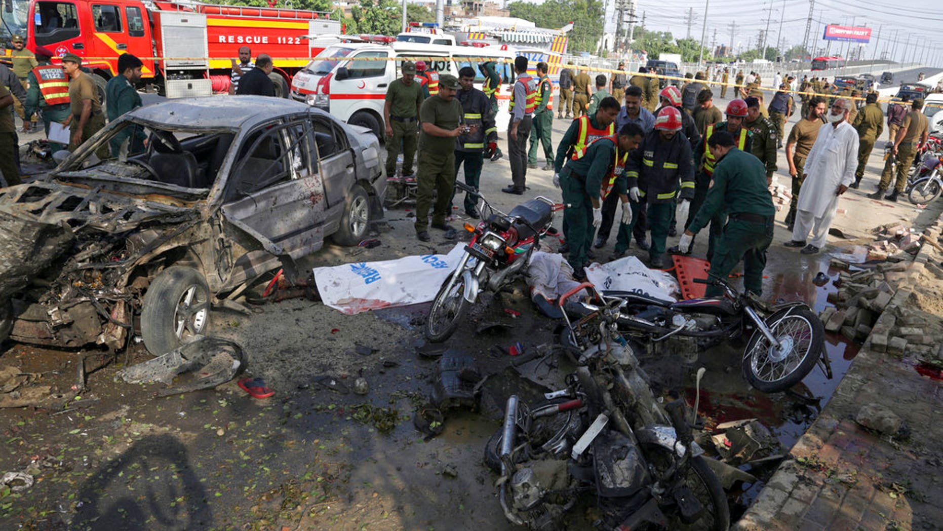 Pakistani rescue workers prepare to remove a body from the site of a deadly bombing in Lahore.