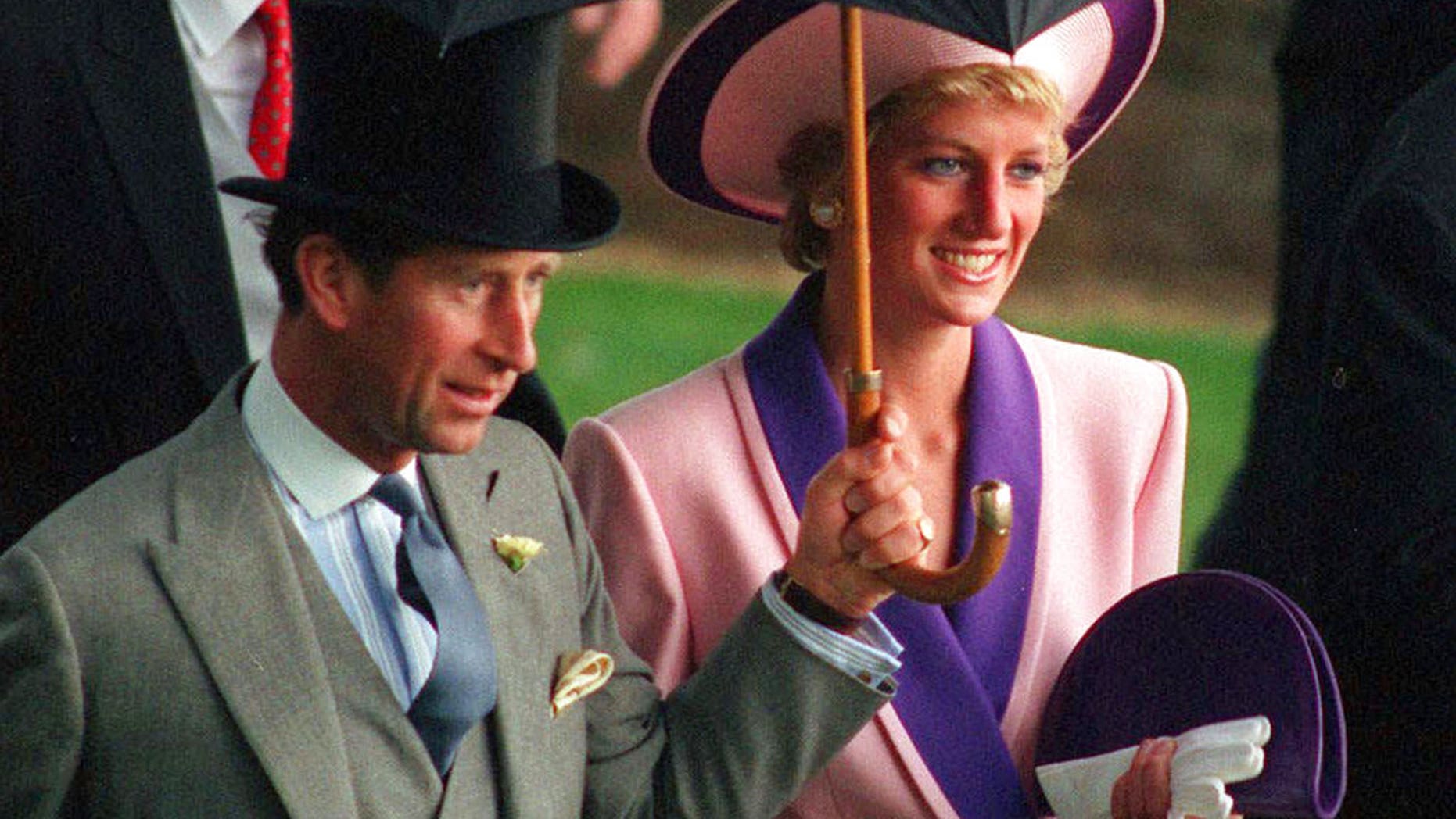 FILE- In this Wednesday, June 20, 1990 file photo, Britain's Princess Diana and Prince Charles, take shelter under an umbrella while attending the second day of the Royal Ascot horse race meet near London. A British television channel is broadcasting a new documentary on Princess Diana using video tapes in which she candidly discussed her marital problems and her strained relationship with the royal family. (AP Photo/Martyn Hayhow, File)
