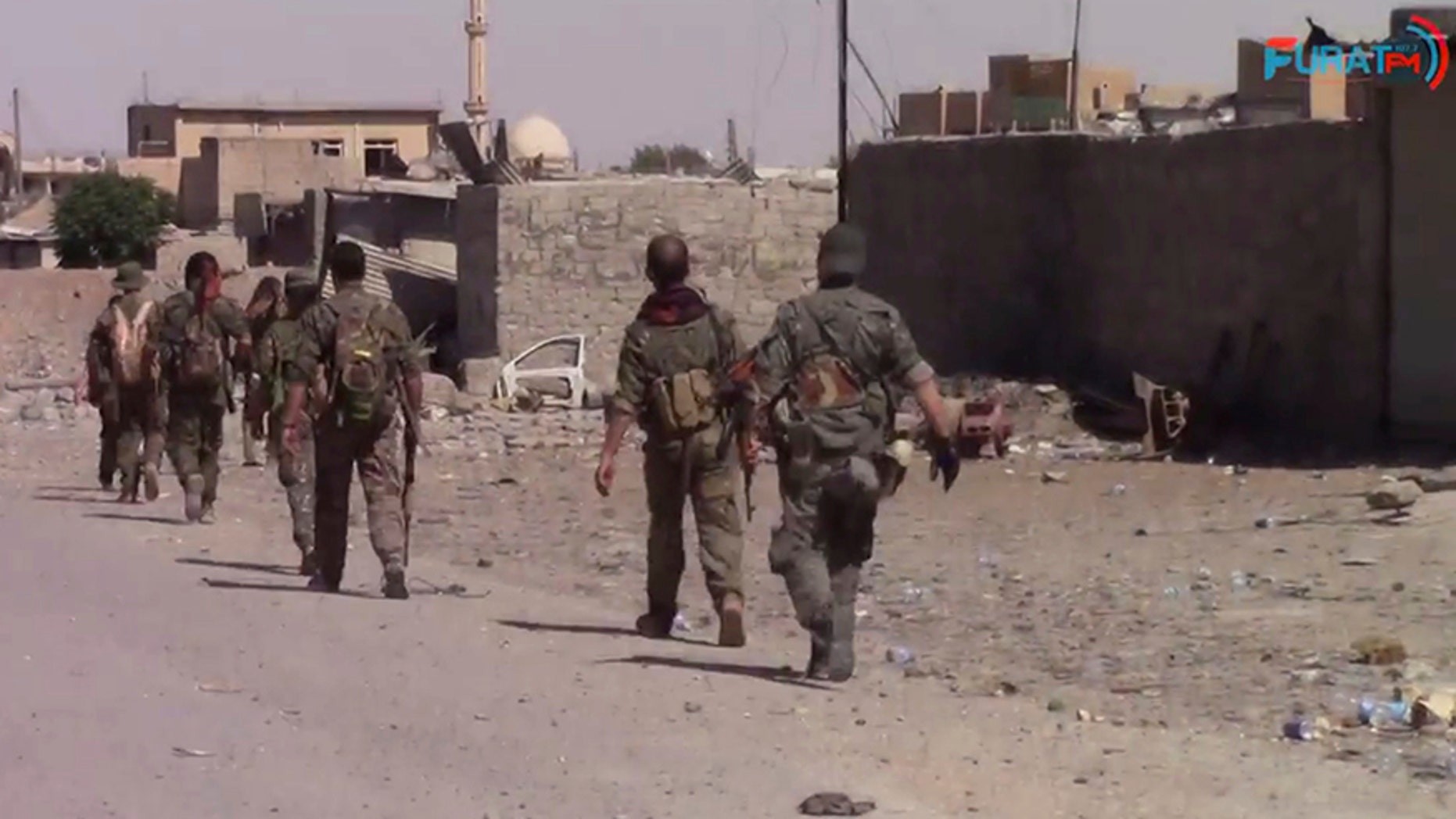 This frame grab from video released Friday, Aug. 11, 2017, and provided by Furat FM, a Syrian Kurdish activist-run media group, shows U.S.-backed Syrian Democratic Forces (SDF) fighters advance in Raqqa, Syria. U.S.-backed Syrian fighters advancing from eastern and western parts of the northern city of Raqqa have linked up for the first time in weeks after launching their offensive against Islamic State group fighters there. (Furat FM, via AP)