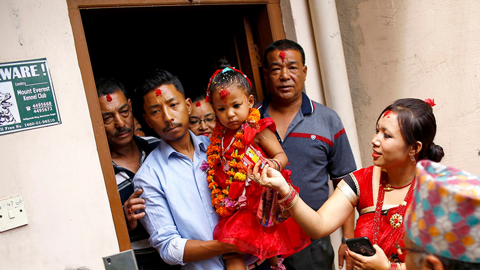 Nepal's new living goddess Trishna Shakya, 3, is carried by her father as they leave home for a temple palace in Kathmandu, Nepal.