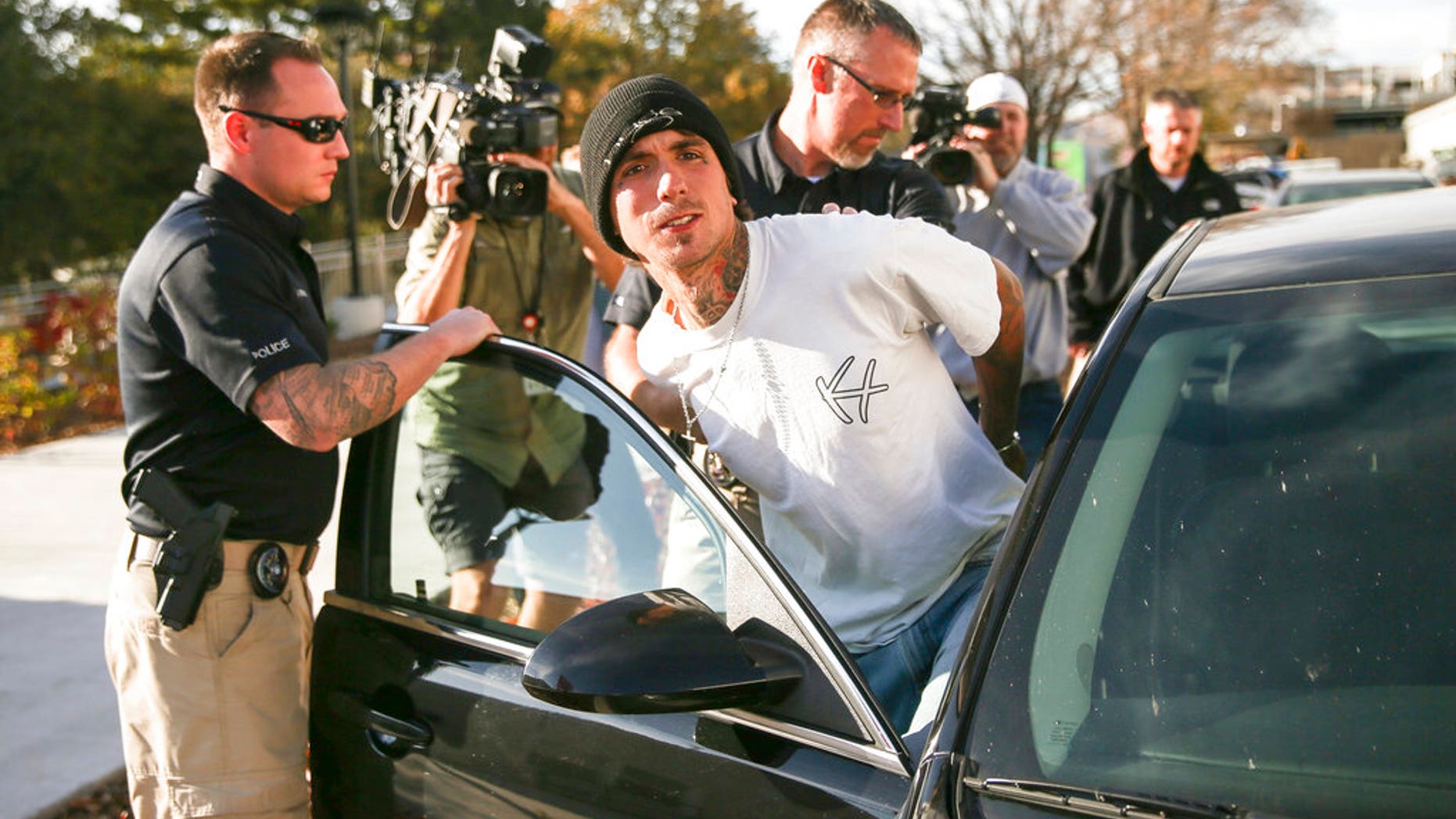 Austin Boutain, a suspect in Monday night's fatal shooting of University of Utah student ChenWei Guo, is led out of the University of Utah Department of Public Safety in Salt Lake City on Tuesday.