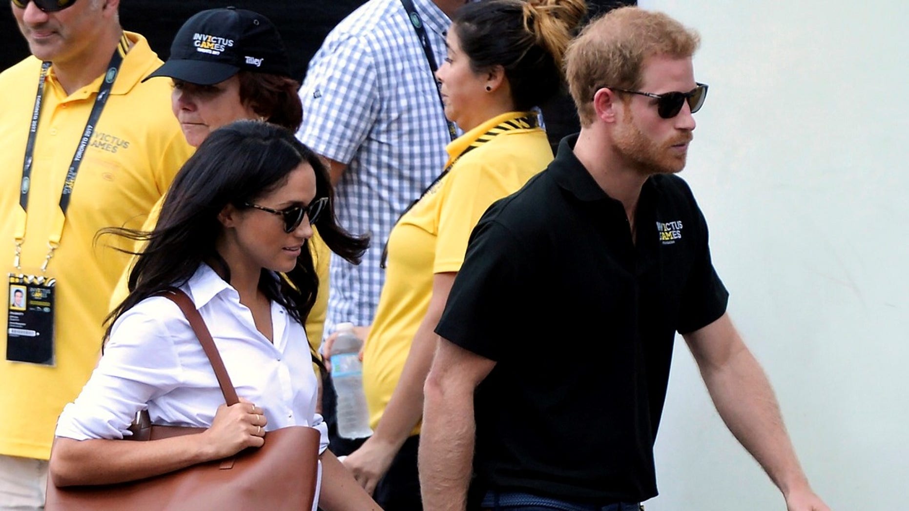 FILE - In this Monday, Sept. 25, 2017 file photo, Prince Harry and his girlfriend Meghan Markle arrive for the wheelchair tennis competition during the Invictus Games in Toronto. Palace officials announced Monday Nov. 27, 2017, Prince Harry and Meghan Markle are engaged, and will marry in the spring. (Nathan Denette/The Canadian Press via AP, File)