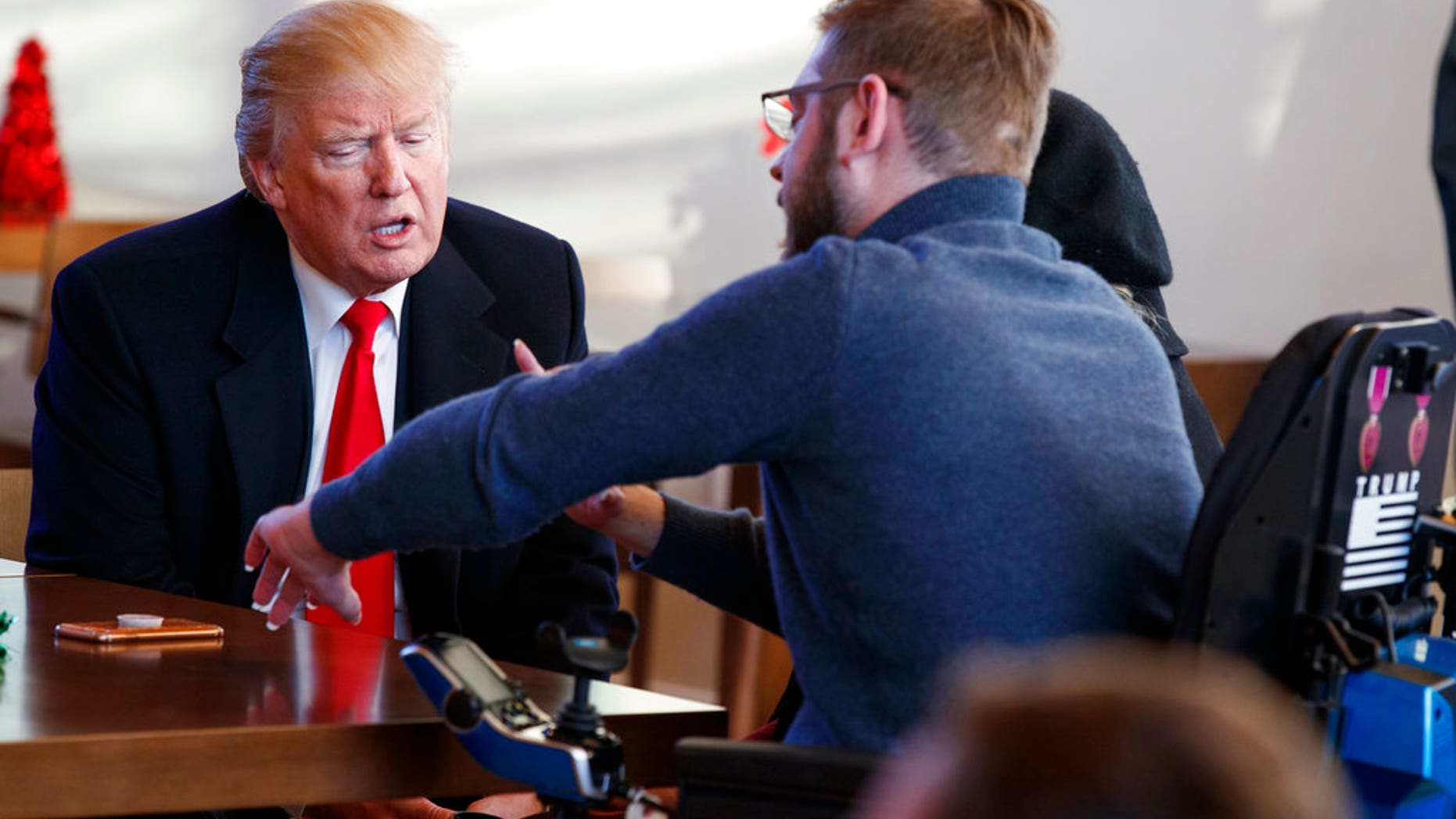 President Trump meets retired U.S. Marine Corps Sgt. John Peck and his wife Jessica during a visit to Walter Reed National Military Medical Center, Thursday, Dec. 21, 2017, in Bethesda, Md.