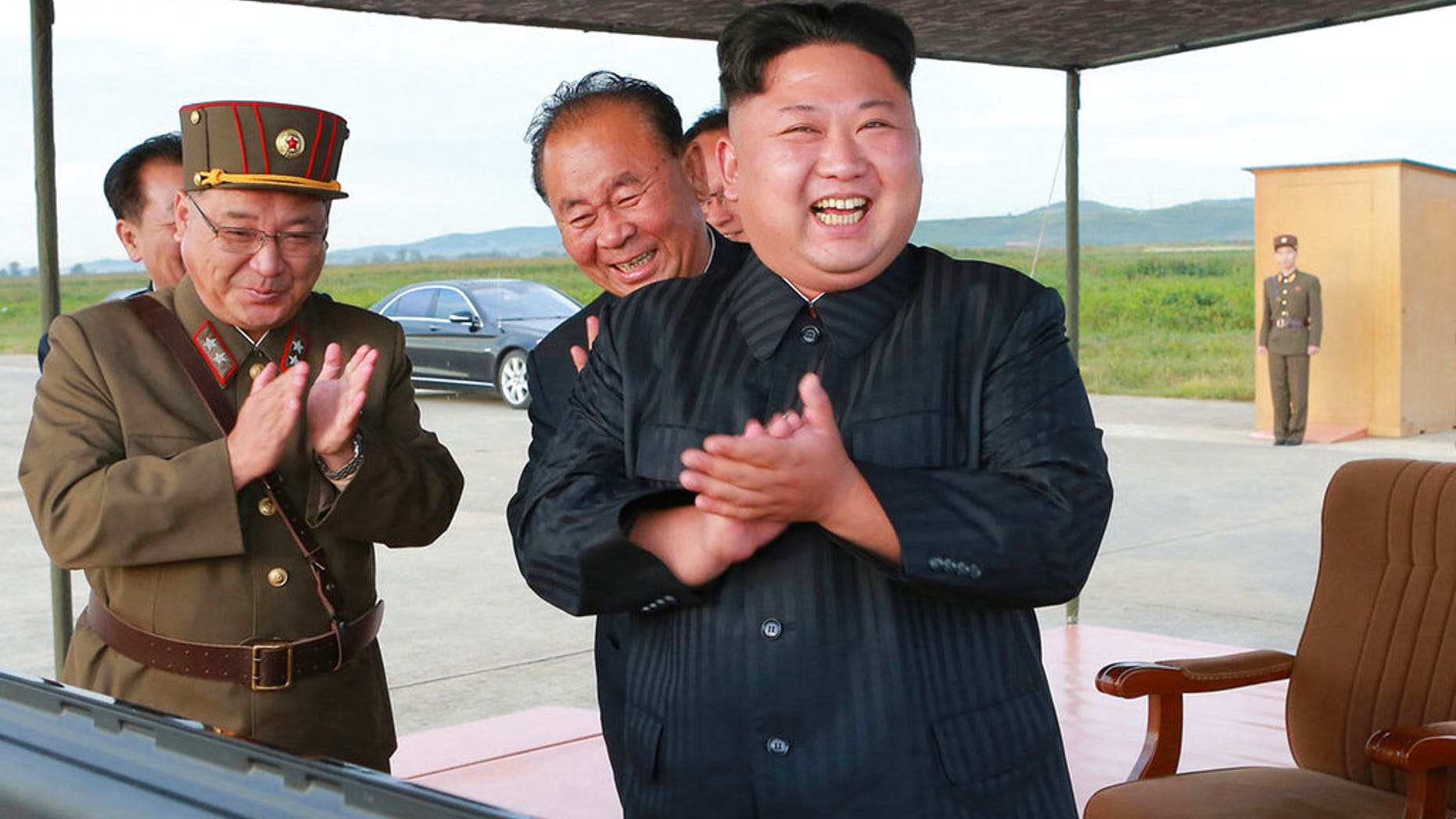 North Korean leader Kim Jong Un celebrates what was said to be the test launch of a Hwasong-12 missile, in an undated government photo that was distributed Sept. 16, 2017.