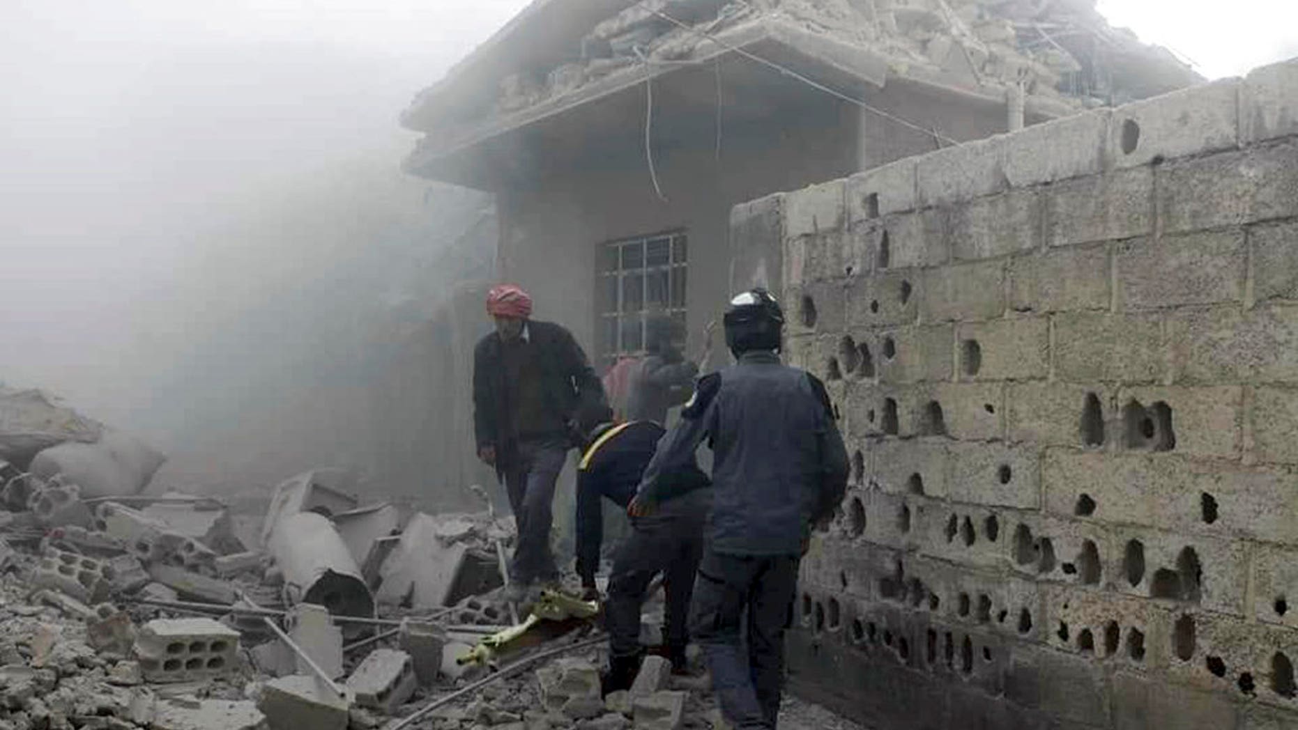 Members of the Syrian Civil Defense group and civilians gathered to help survivors from a street attacked by airstrikes and shelling by Syrian government forces in Ghouta, a suburb of Damascus, Syria.