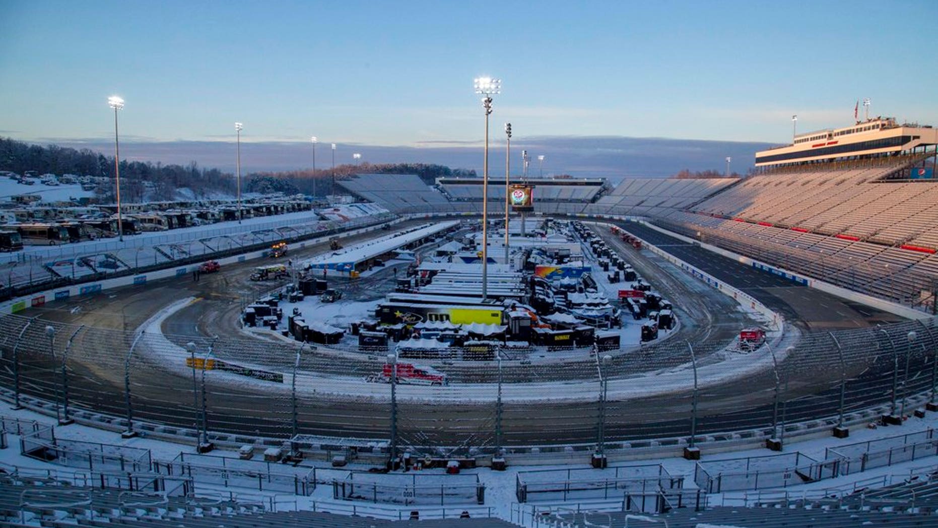 Snow rests on the ground at Martinsville Speedway in Martinsville, Va., Sunday, March 25, 2018. The NASCAR Cup Series race at Martinsville Speedway was postponed until Monday because of inclement weather. (AP Photo/Matt Bell)