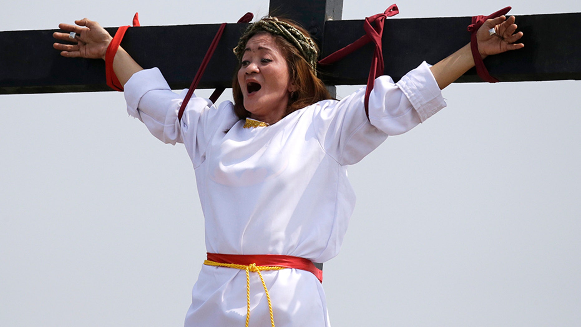 Maryjane Sazon, a 39-year-old beauty salon worker, grimaces as she gets nailed to the cross as part of Good Friday rituals in the village of San Pedro Cutud, Pampanga province, northern Philippines.
