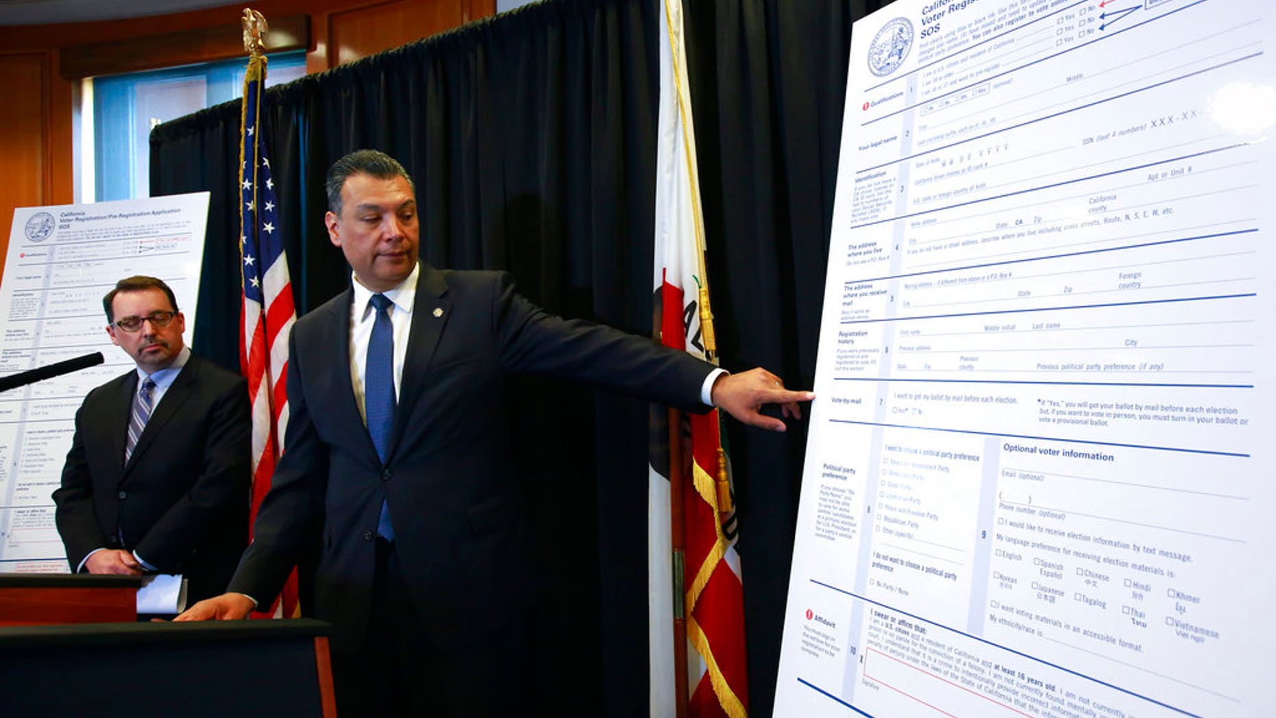 California Secretary of State Alex Padilla, right, points out details on the state's updated voter registration form.