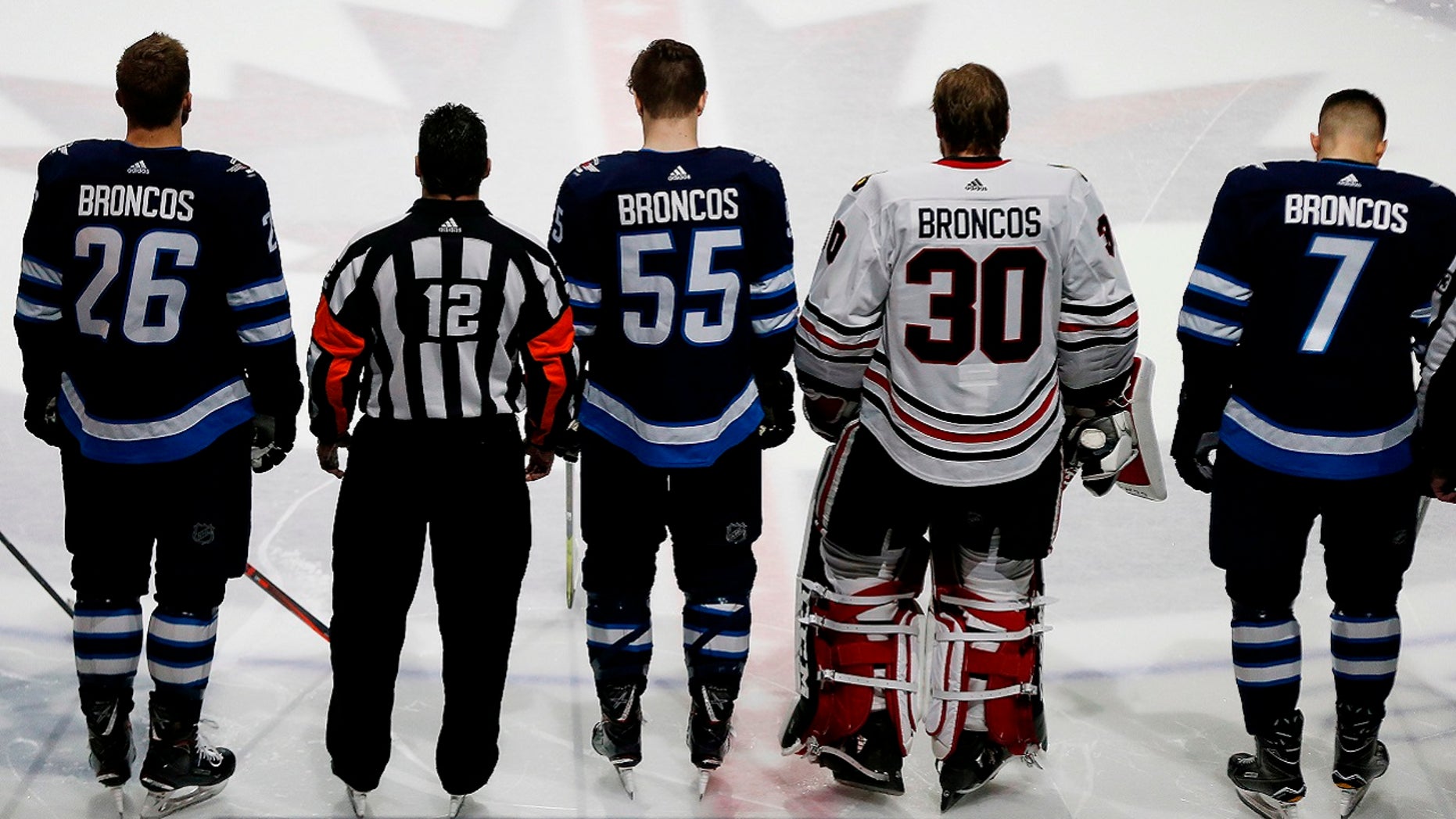 Winnipeg Jets and Chicago Blackhawks players wear "BRONCOS" on the back of their jerseys instead of their own names in a tribute to young players from Humboldt, Sask., who died in a bus crash, April 7, 2018.