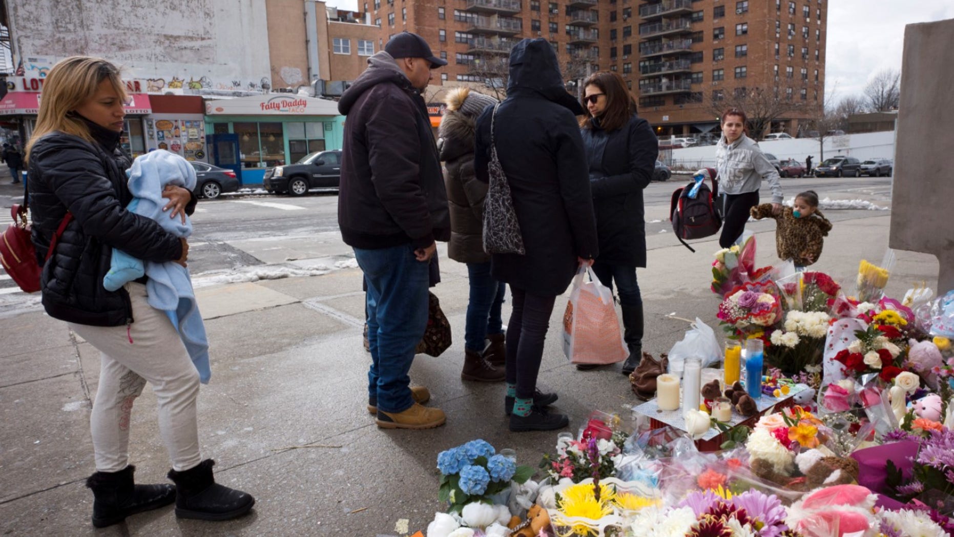 People gather at a sidewalk memorial for two children who were killed in March when they were struck by a car driven by a woman who likely had a seizure behind the wheel, in the Park Slope neighborhood of the Brooklyn borough of New York. The driver, Dorothy Bruns, was arrested at her Staten Island home on Thursday, May 3, and has been charged with manslaughter.