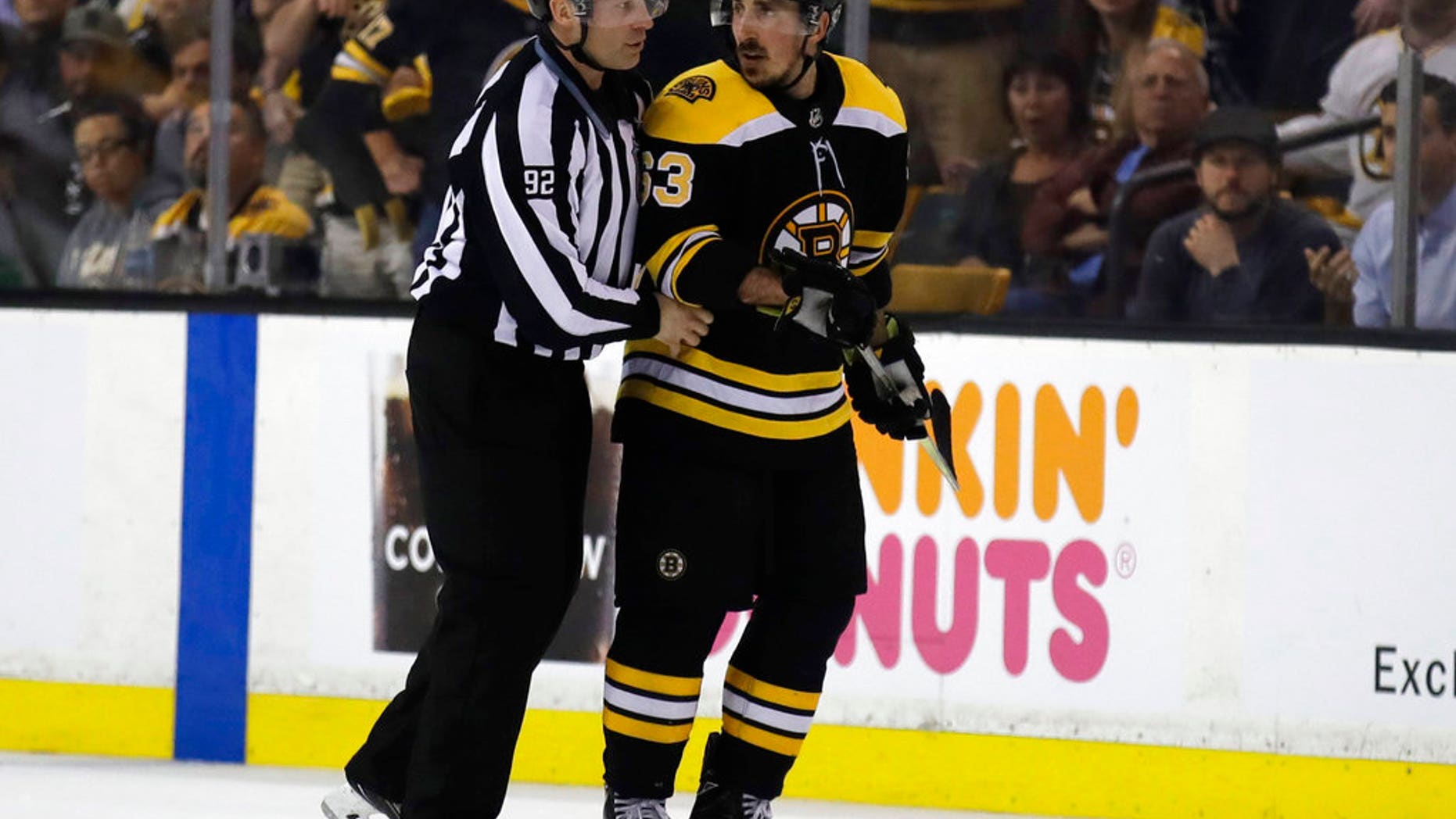 Brad Marchand of the Boston Bruins is escorted to the penalty box during the second period of a match against the Tampa Bay Lightning, in Boston, May 2, 2018.