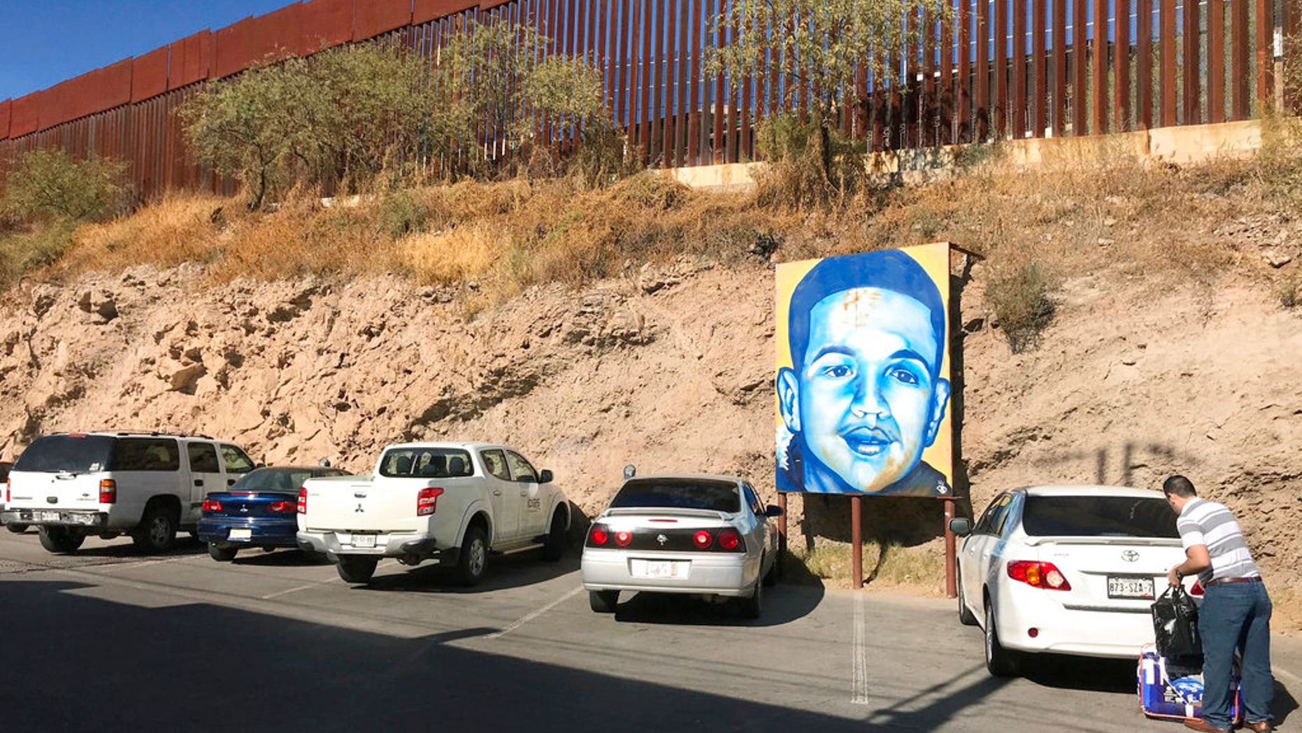 A portrait of Mexican youth Jose Antonio Elena Rodriguez, who was fatally shot in 2012, is displayed along the street where he died, in December 2017.