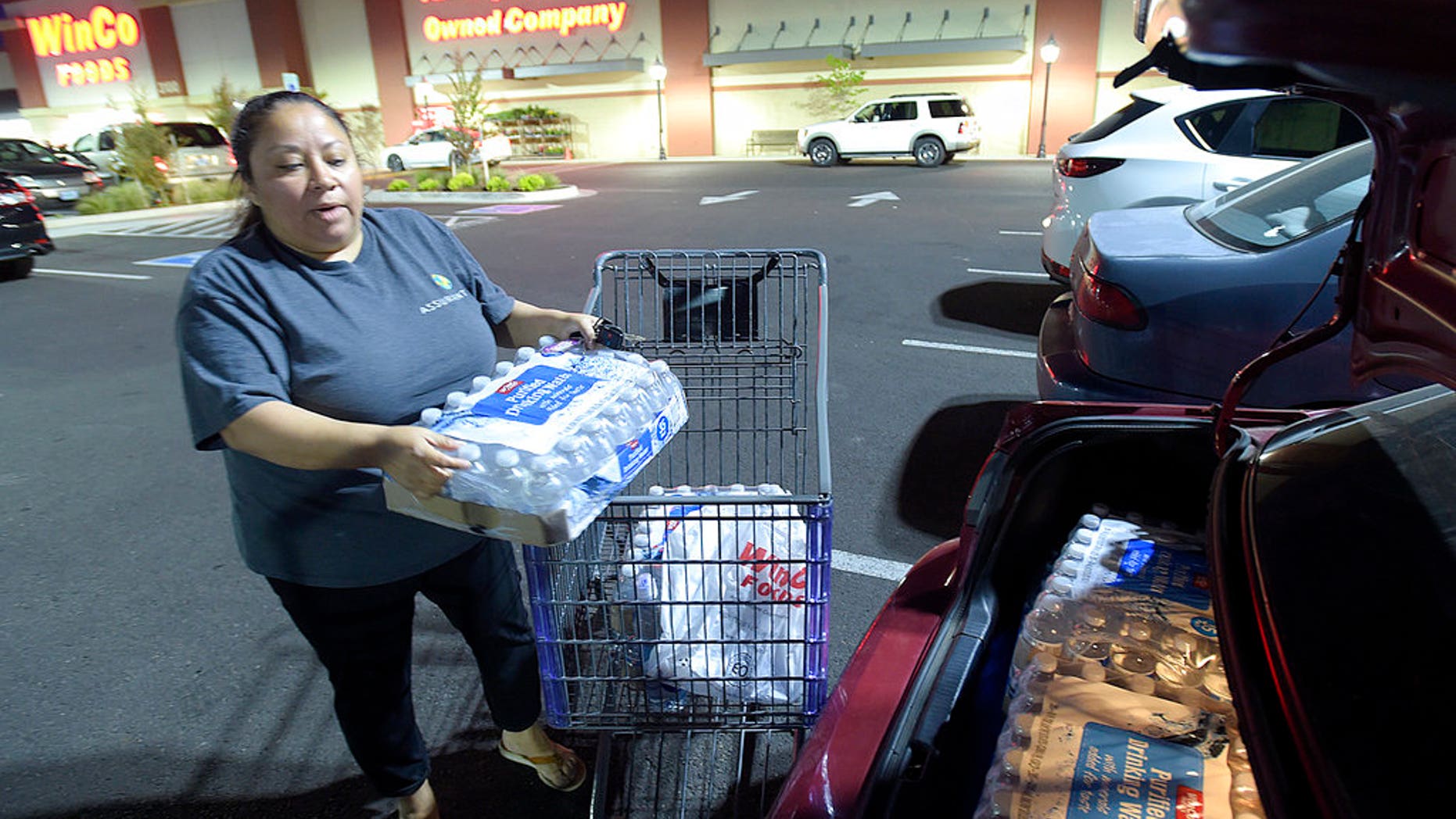 Juana Francisco of Albany, Ore., loads her trunk with water purchased at WinCo, May 29, 2018.